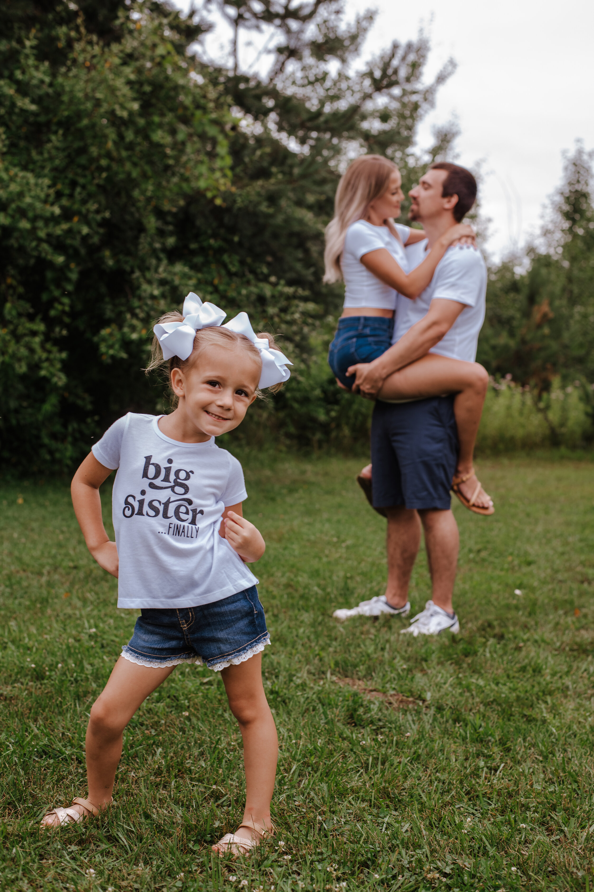 Candid photo of a Big sister announcement during a family photography session by Forever Ago Photography. Capturing the joy and wonder of childhood with authentic, timeless images in Carleton Michigan