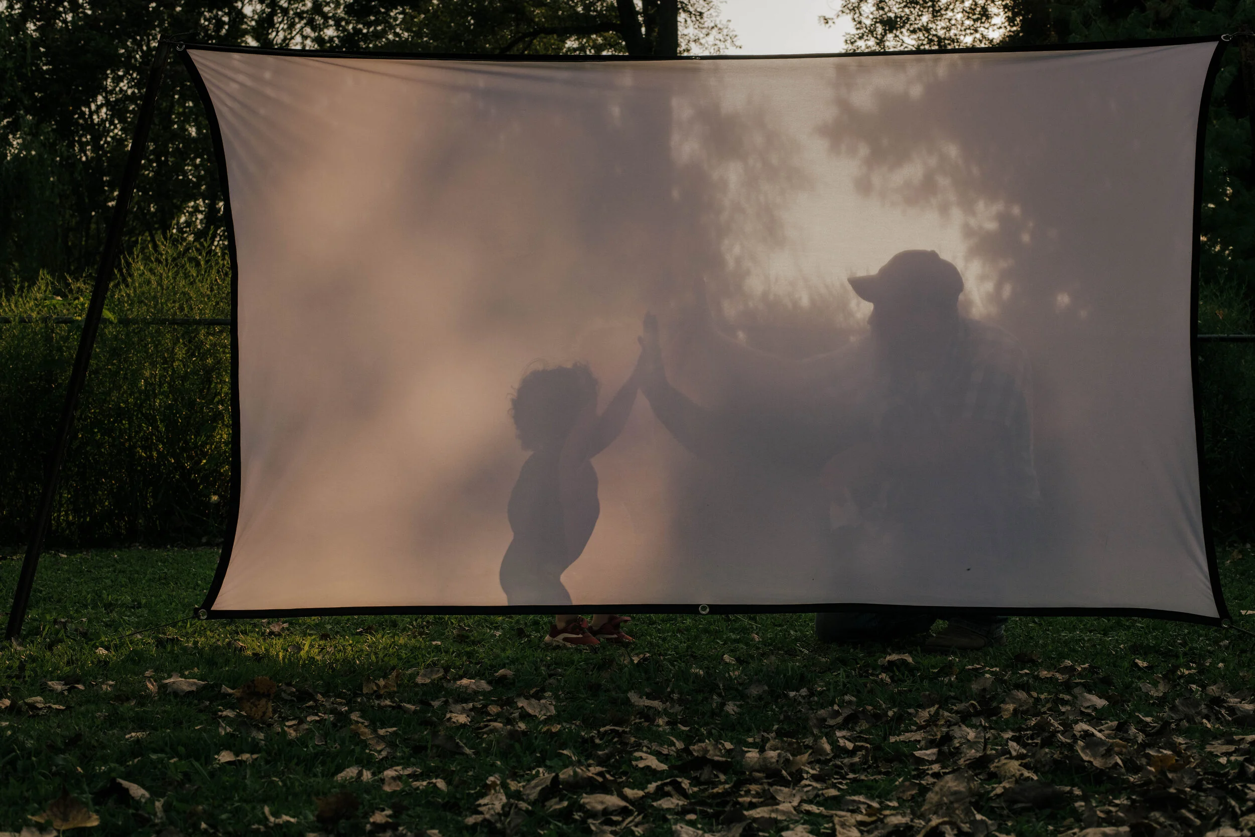 Heartfelt photo of a dad preparing an outdoor theater for a summer family gathering, captured by Forever Ago Photography. Highlighting the beauty of meaningful family moments in Toledo Ohio