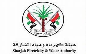 Logo of Sharjah Electricity & Water Authority featuring a palm tree between two black and red water hoses wrapped in a ribbon with the UAE flag colors.