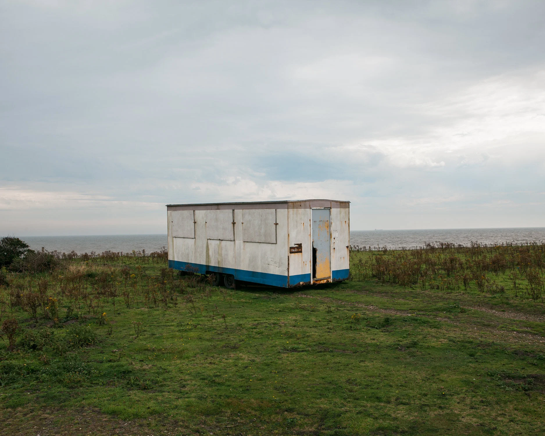 An abandoned boarded up static home is left on the cliffside in Sussex.