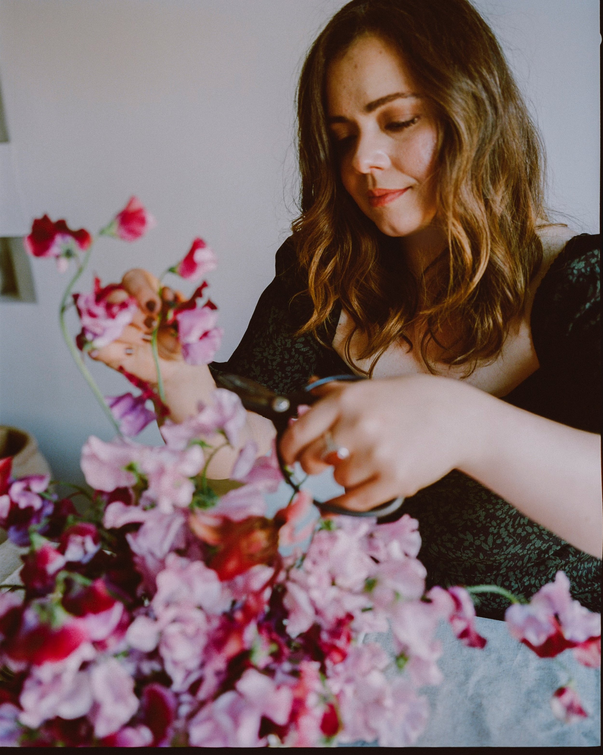 Tasha arranging floral design featuring seasonal blooms