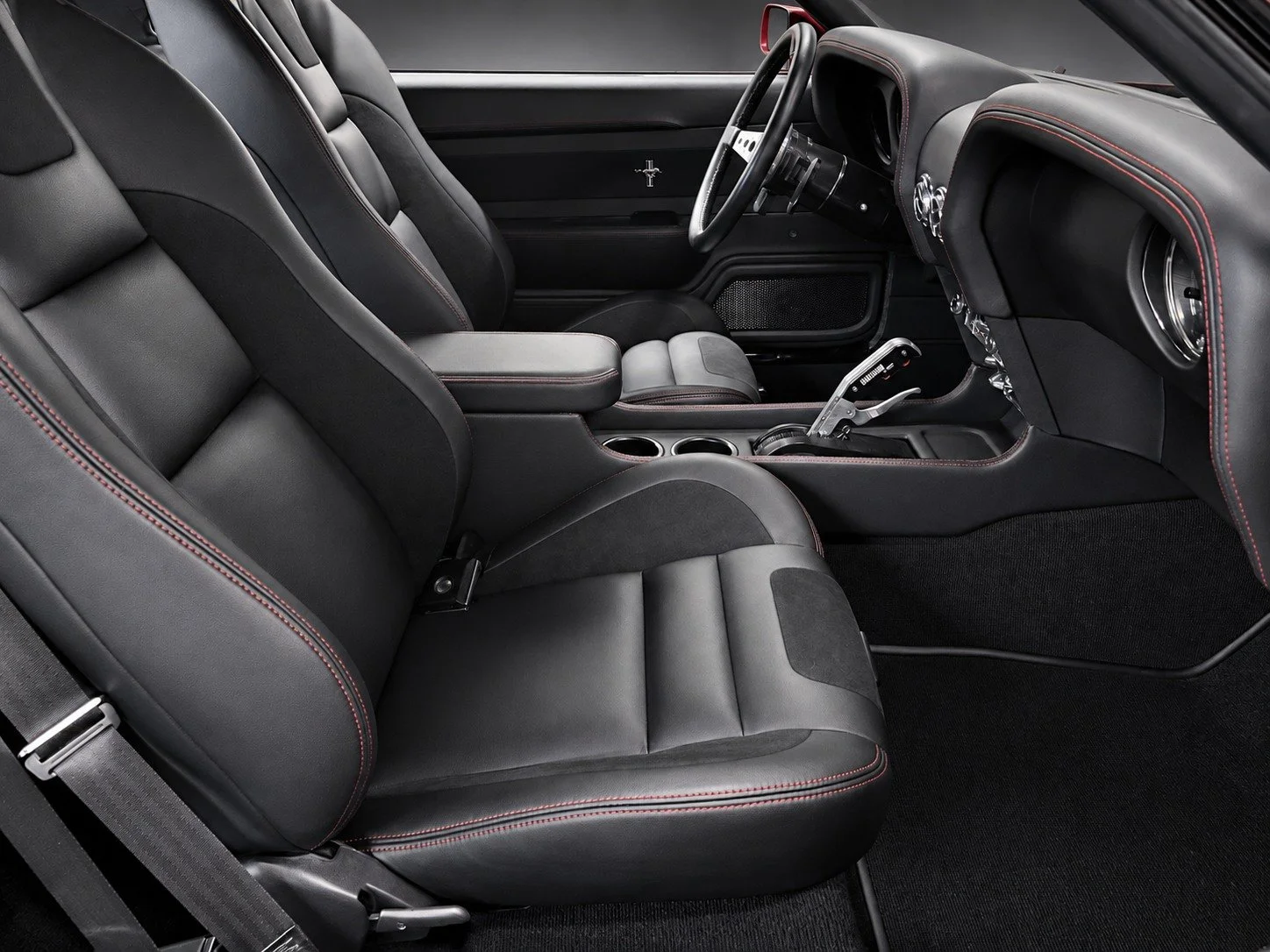 A 1969 Ford Mustang Mach 1 custom leather interior with red stitching and a matching center console.