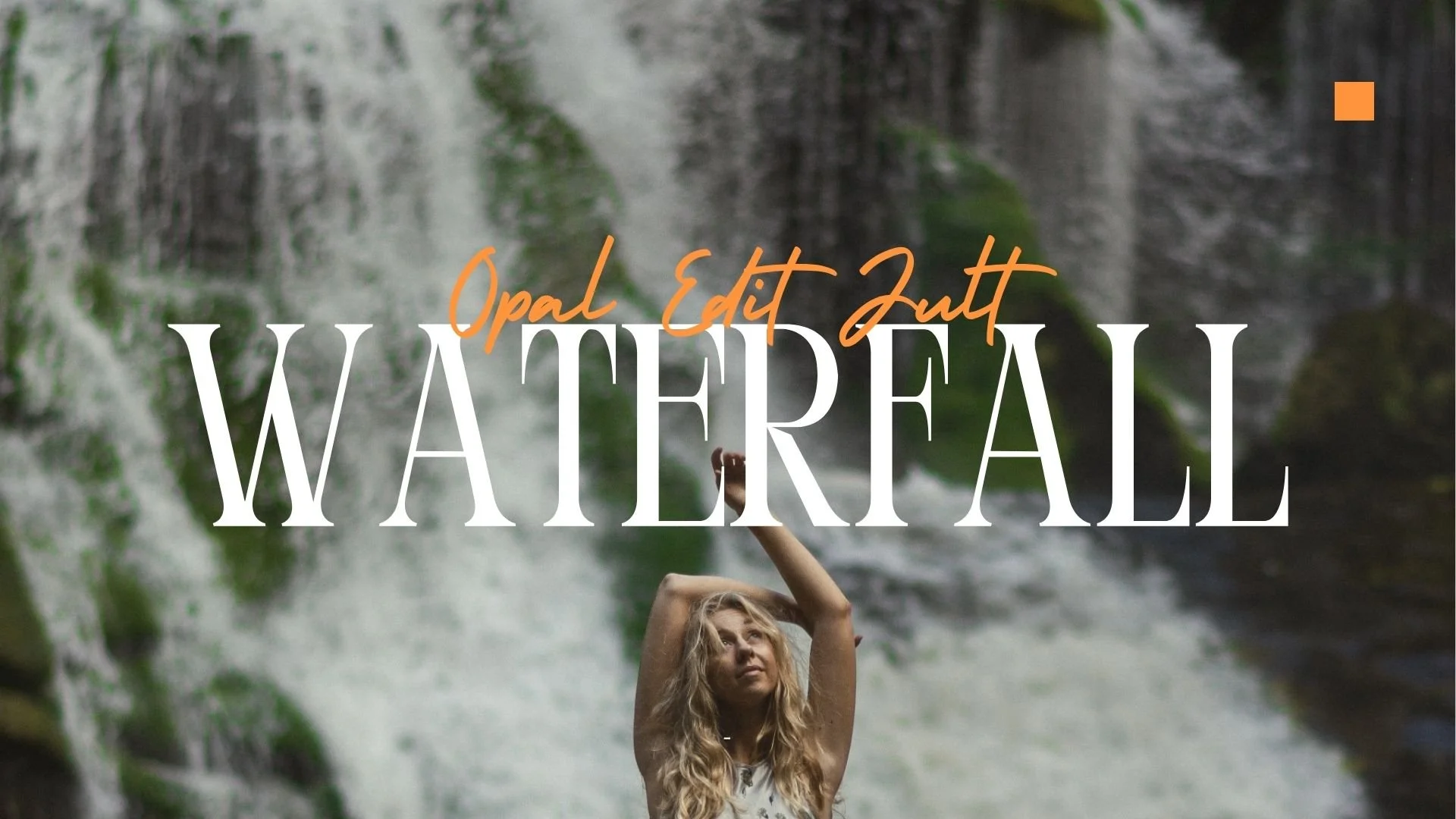 A woman with long blonde hair stretching her arms above her head in front of a waterfall with lush green moss and rocks.