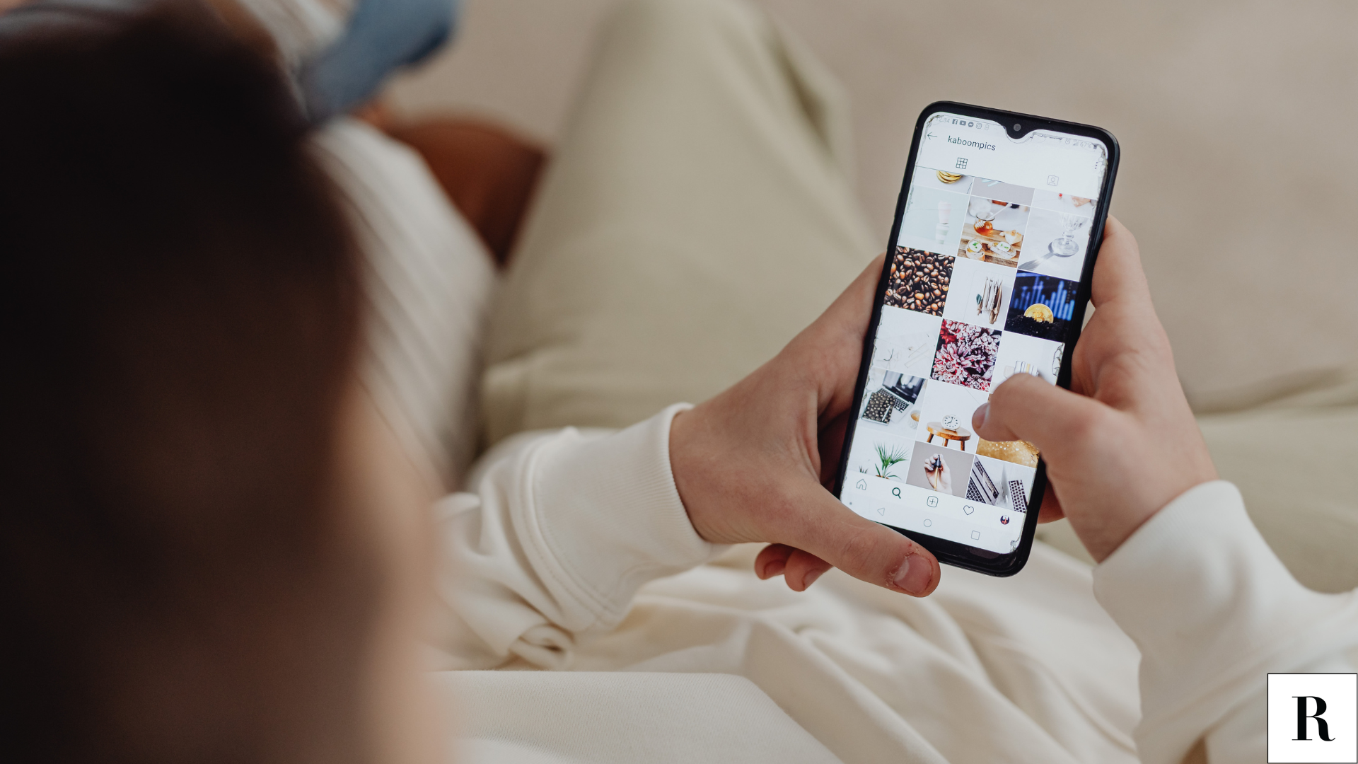 an over shoulder image of a woman looking at her phone opened to an Instagram grid
