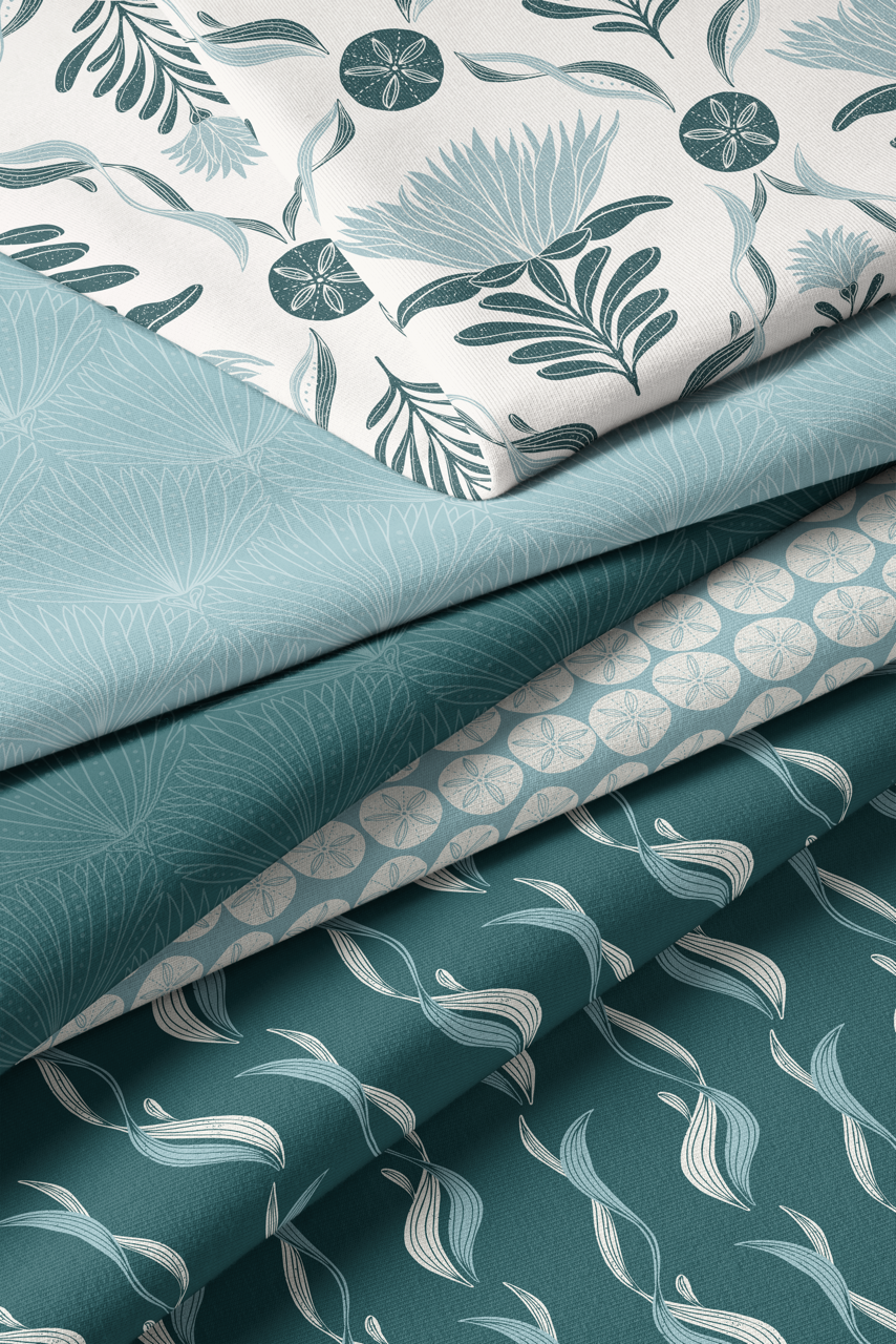 Coastal fabric collection featuring botanical and sand dollar prints in teal, sage, and cream