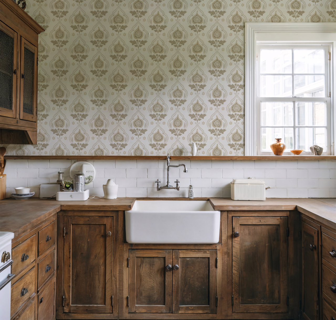 Ochre and cream fig block print damask wallpaper in a farmhouse kitchen with wood cabinetry and a white apron sink