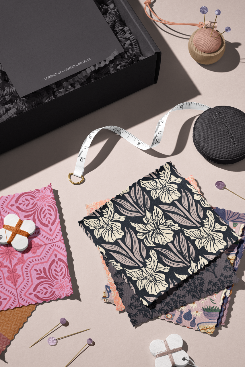Designer fabric swatches featuring Folk Petal Tile in hot pink and Modern Iris Damask in black and cream, styled with a fabric measuring tape.