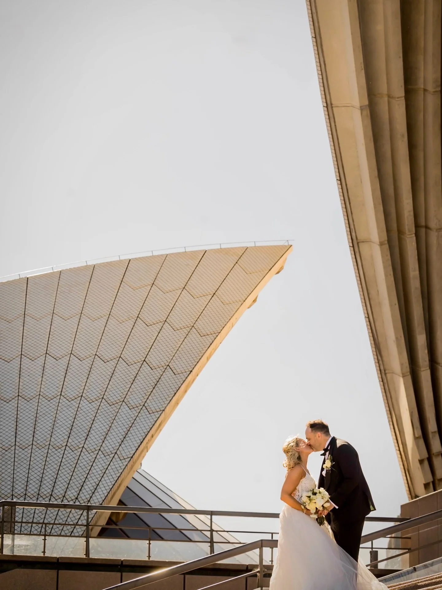 Standing in that perfect Sydney golden light, watching love happen naturally in front of one of the world&rsquo;s most iconic backdrops. 🇦🇺
Wide lens, big architecture, small intimate moment &mdash; that&rsquo;s always the magic for us. 
The Sydney