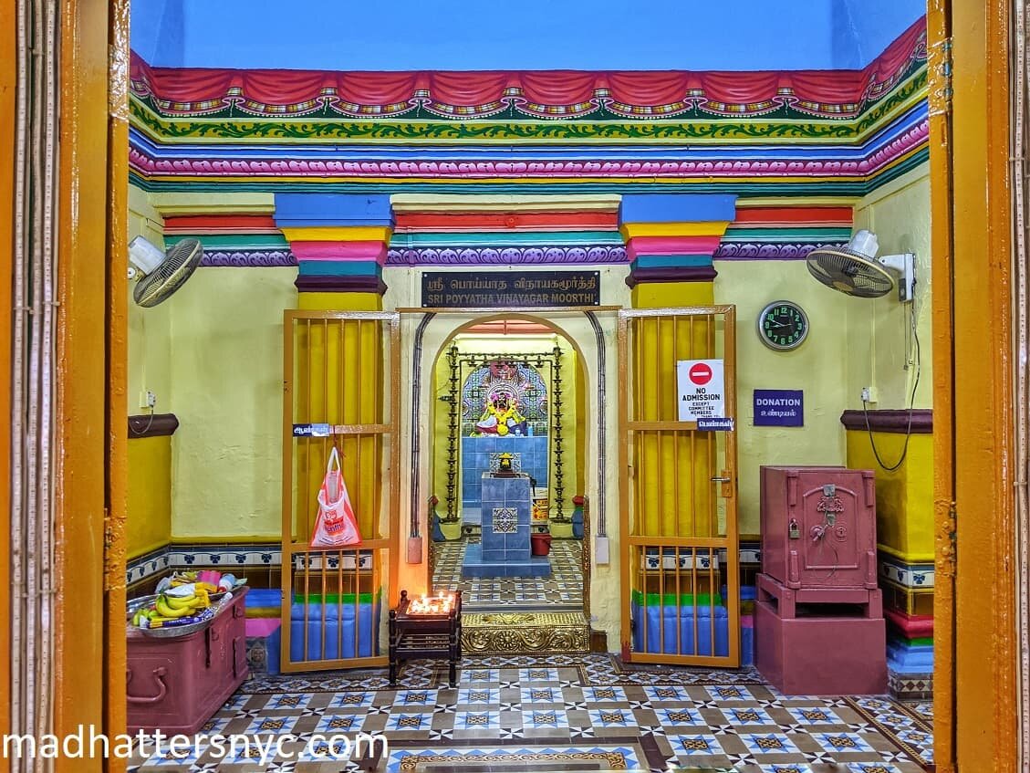 Colorful interior of Sri Poyyatha Vinayaga Moorthy Temple with painted trompe l'oeil moldings and printed tiles in Melaka, Malaysia