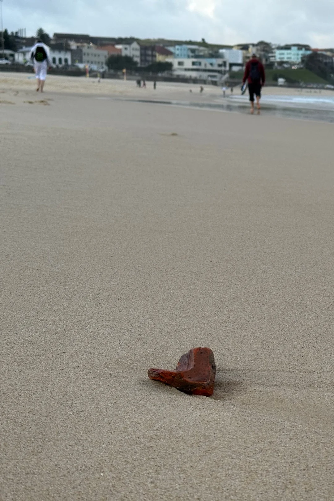 This looked like some kind of heart-shaped brick washed up from the ocean at Bondi Beach. My mom and Travis are walking in the background.