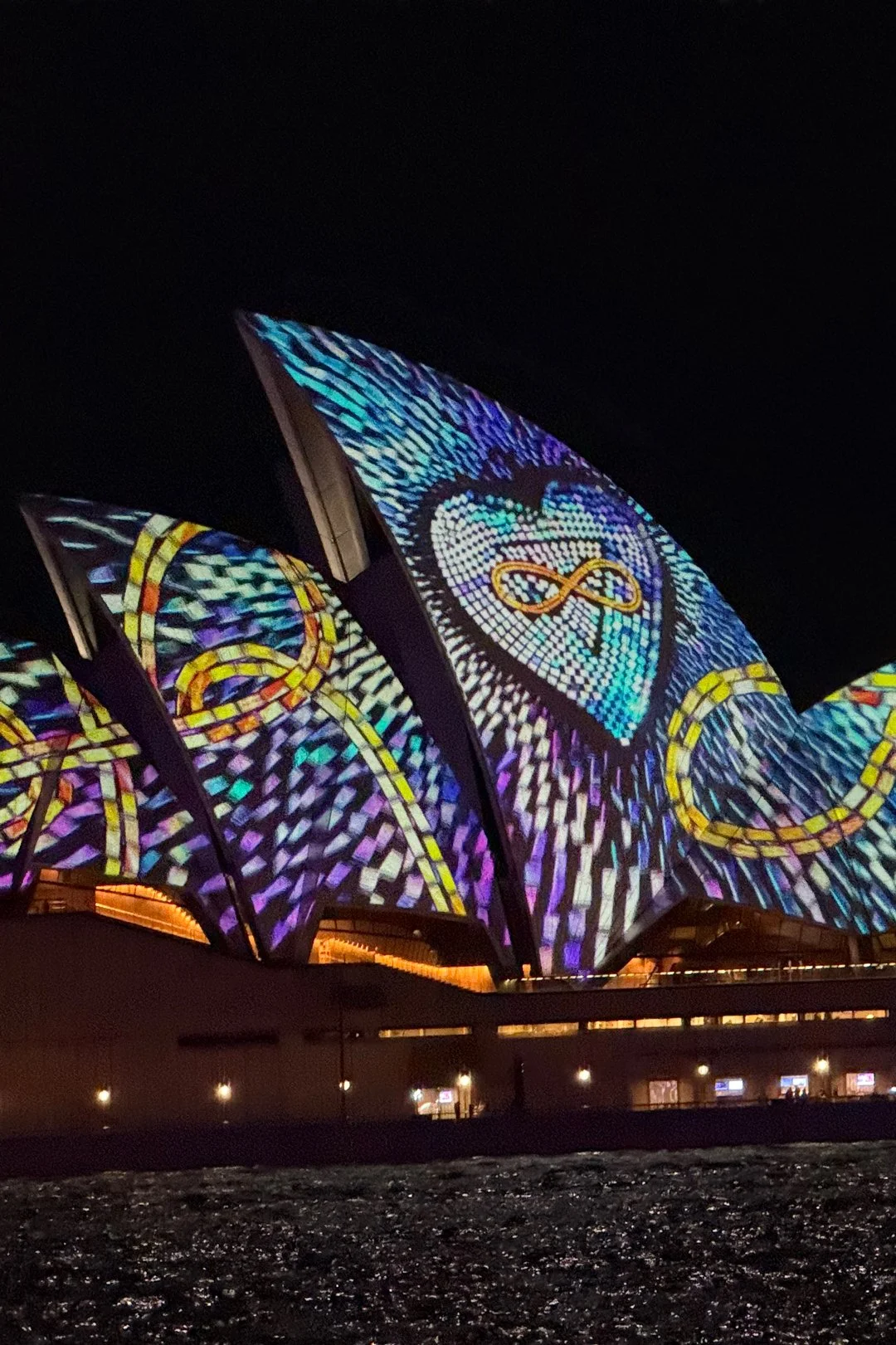 The Sydney Opera House, Harbour Bridge, ferries and buildings lit up every night with colorful lights and patterns during the city's Vivid Sydney event.