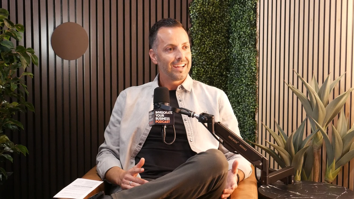 George Stroumboulis hosting Invigorate Your Business with a branded microphone in the Newport Beach studio