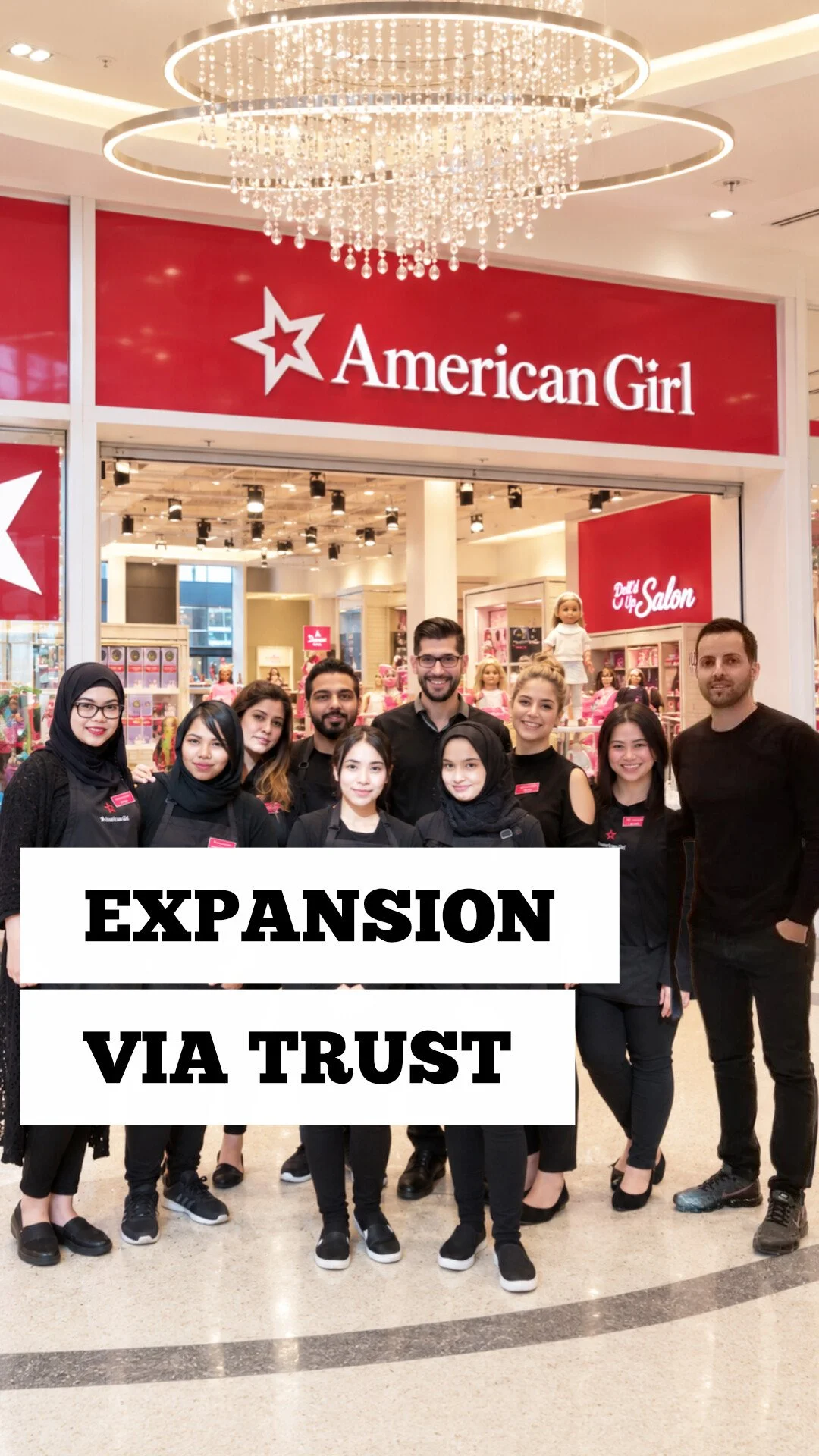 George Stroumboulis with the American Girl team outside a store beneath a ring chandelier, with the words Expansion Via Trust overlaid.