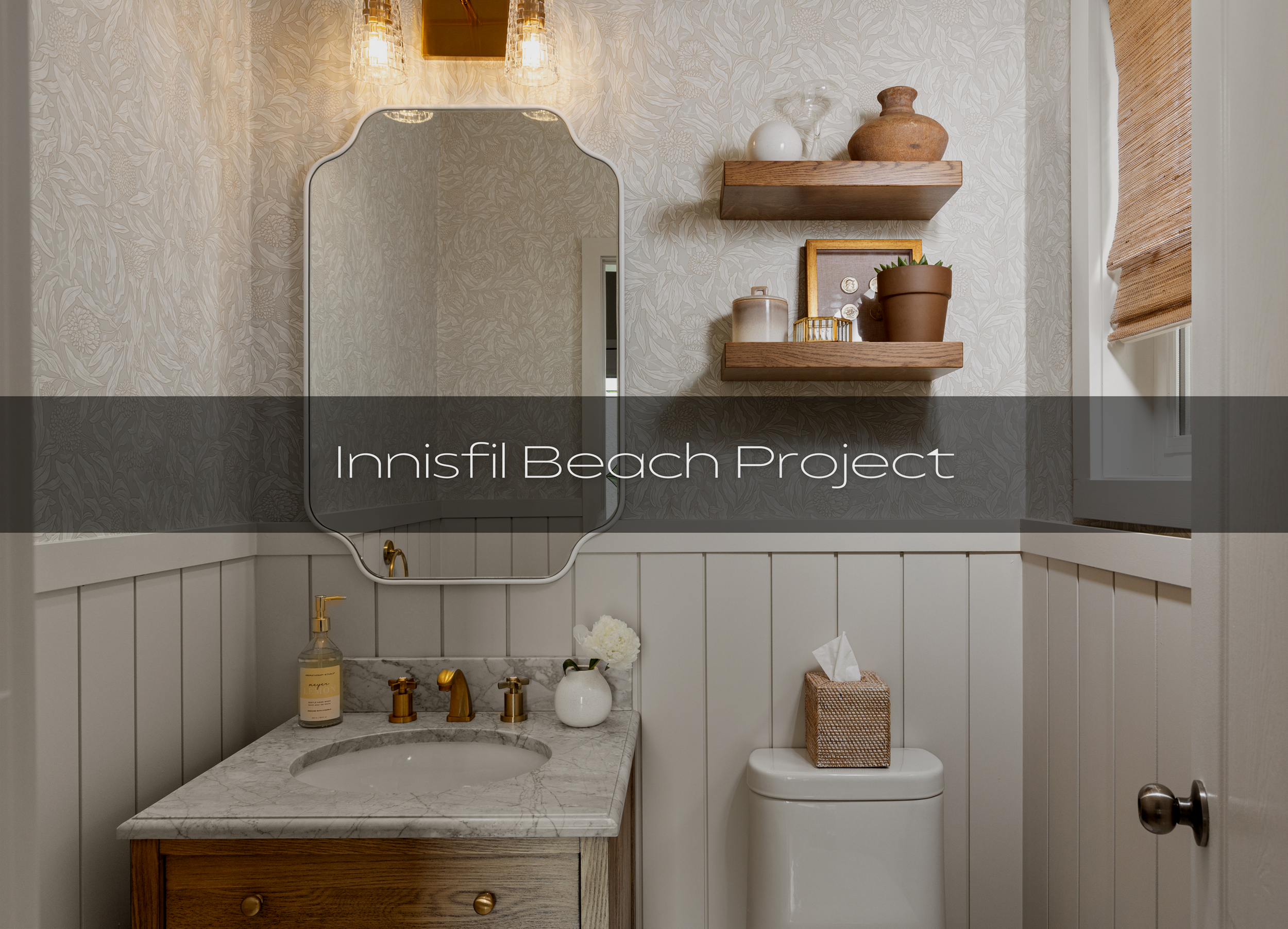 Innisfil beach powder room. A small bathroom with floral wallpaper, white wainscoting, a marble countertop sink with gold fixtures, a white vase with flowers, a soap dispenser, a tissue box, and two floating wooden shelves with decorative items, a mi