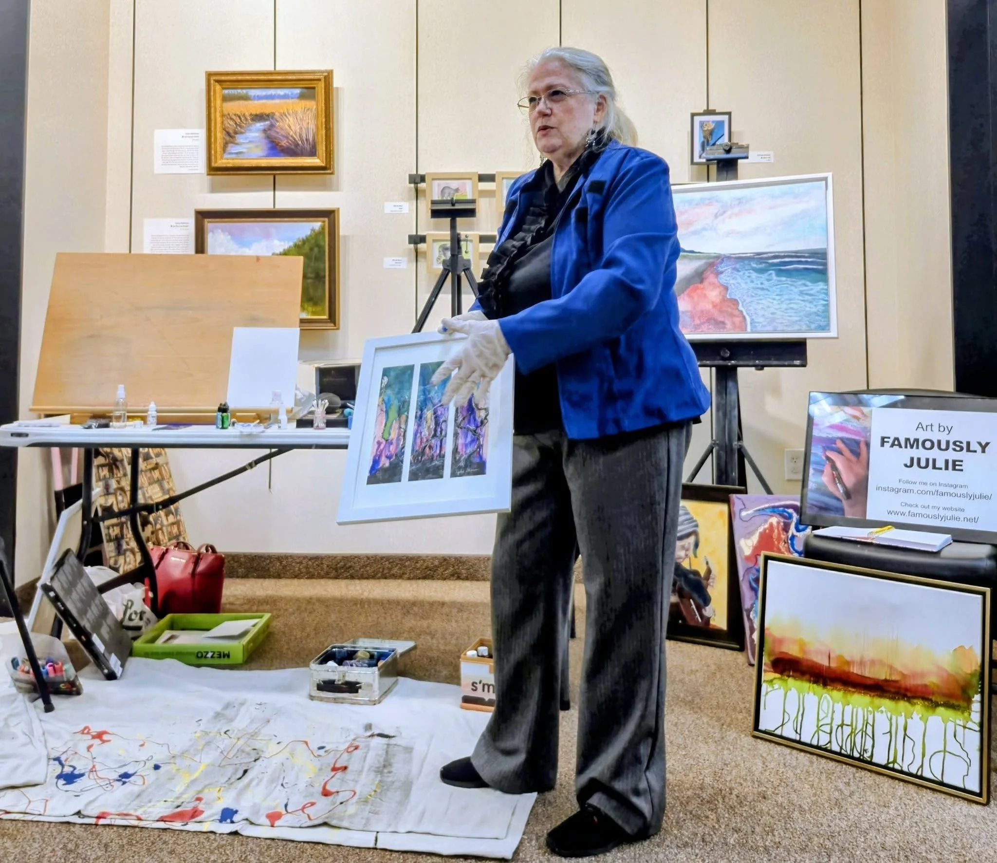 Famously Julie conducting a painting demonstration at HMA pilot location using alcohol inks on paper and canvas to a group of spectators.