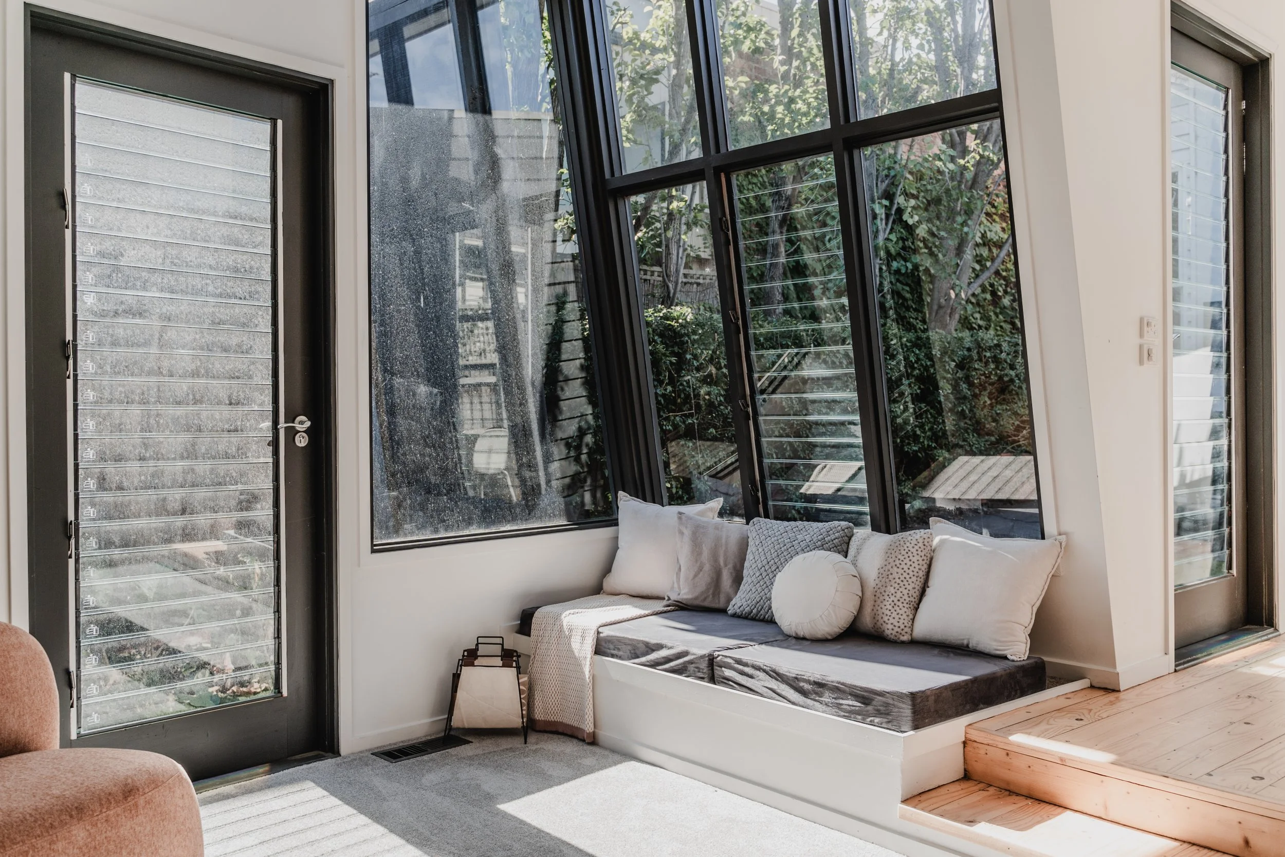 Window seat with cushions overlooking garden in St Kilda Airbnb