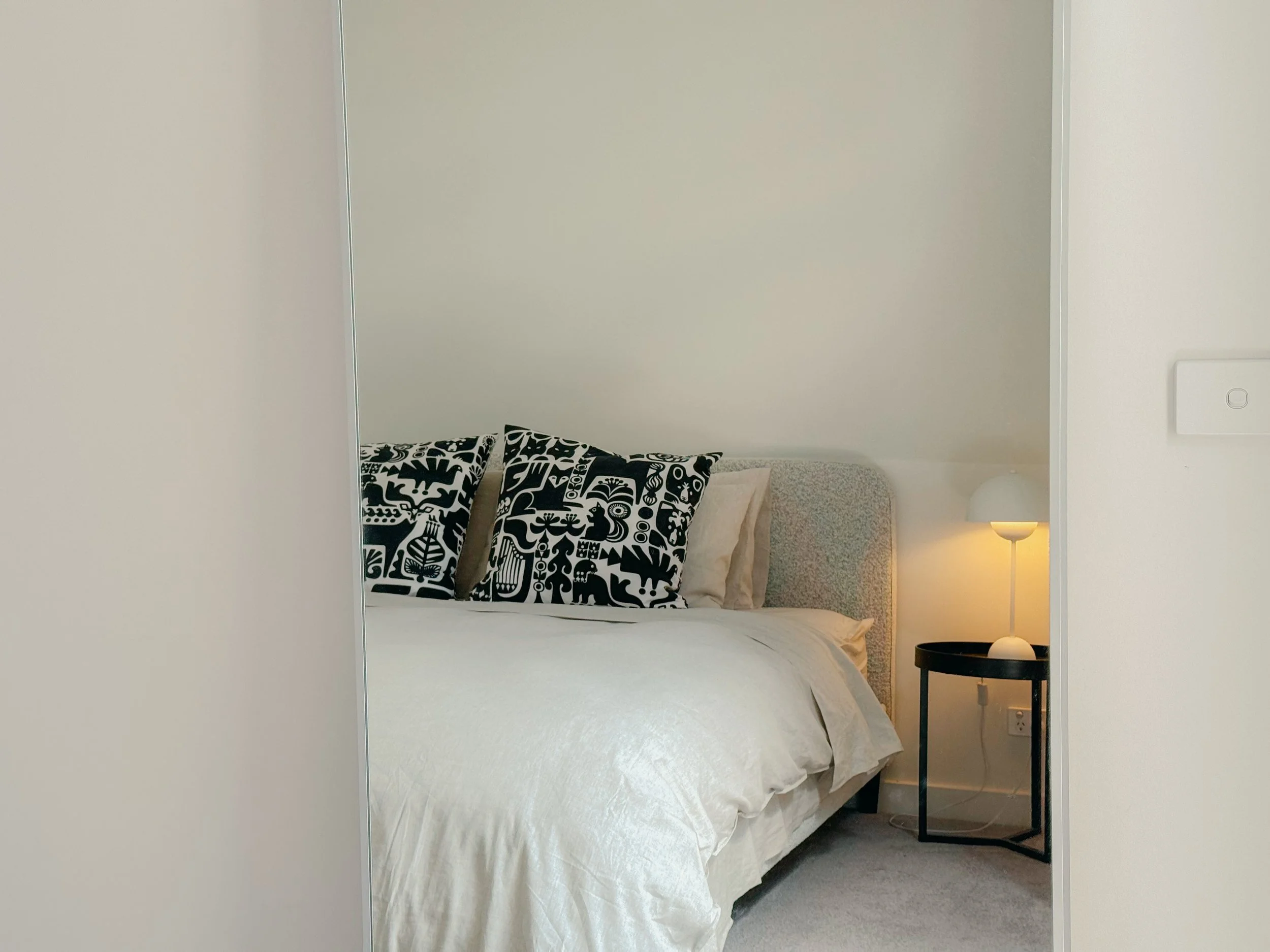 Bed with printed cushions in Collingwood short-stay apartment