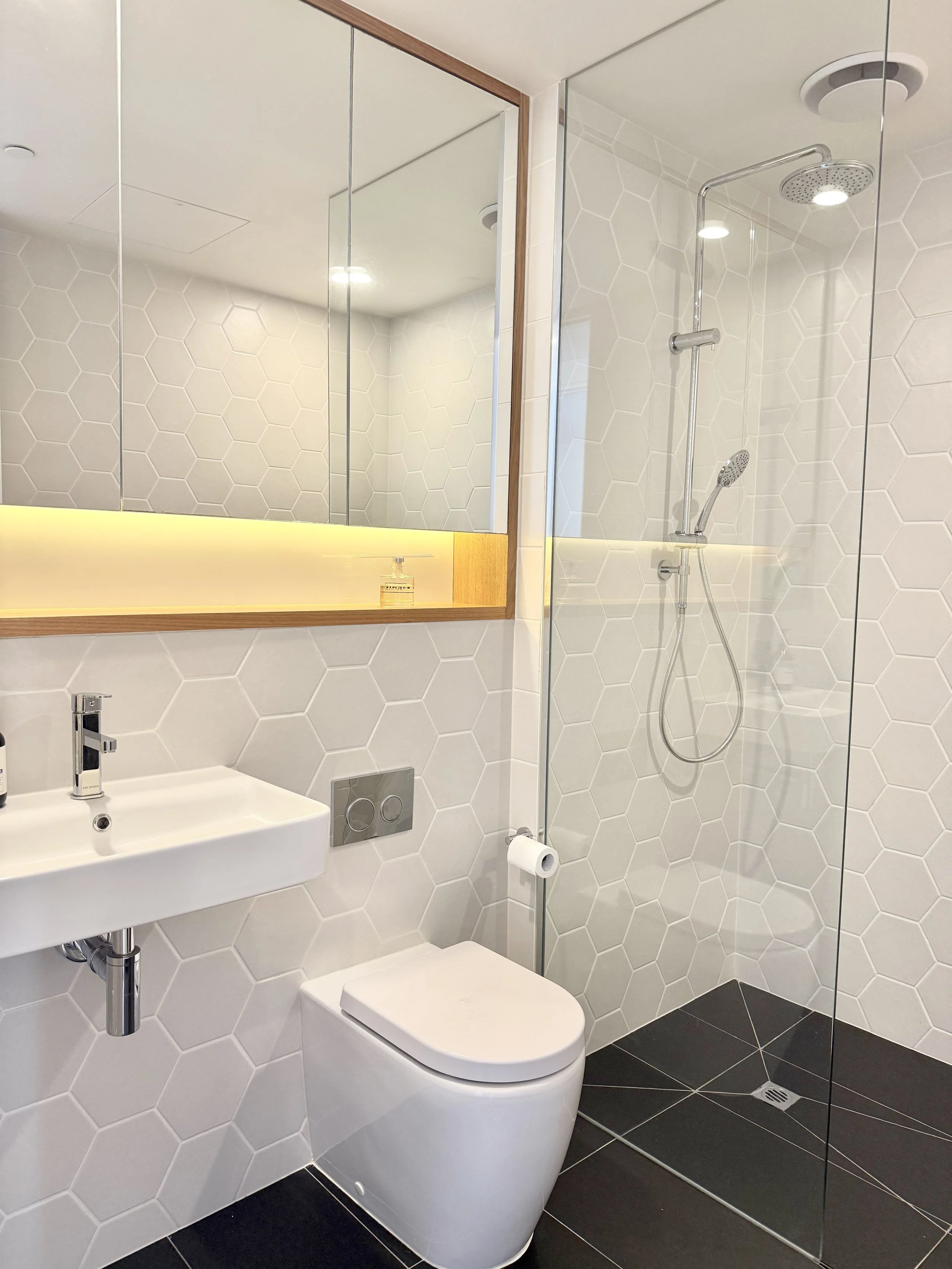 Bathroom with shower and lit mirror in Collingwood 2-bathroom apartment