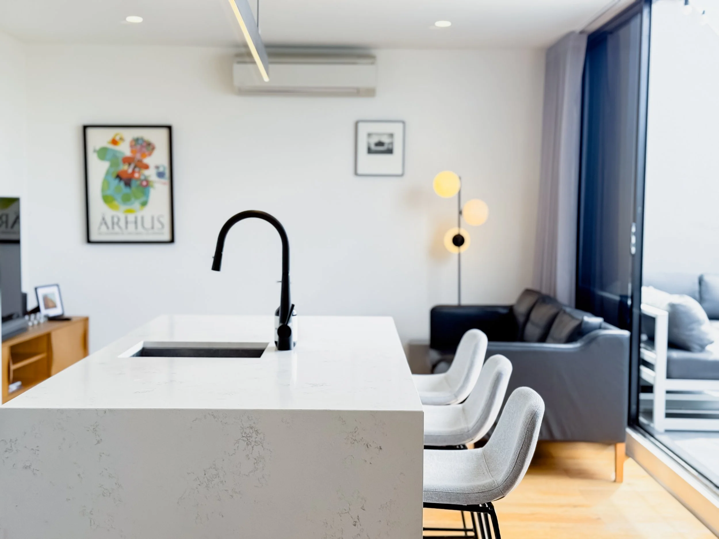 Kitchen island with stone benchtop and black tap in Collingwood Airbnb apartment