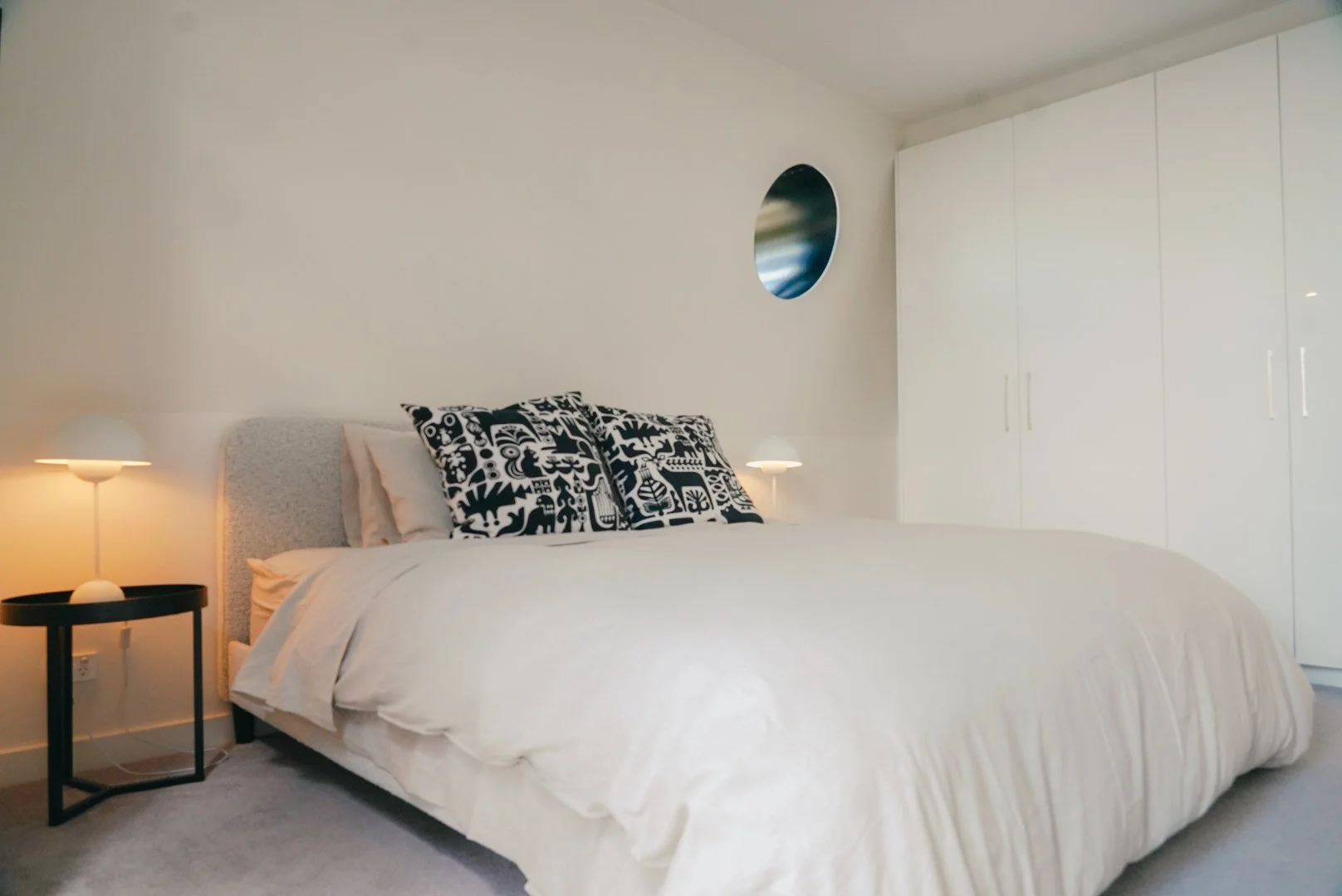 Second bedroom with round mirror in Collingwood 2-bedroom Airbnb apartment