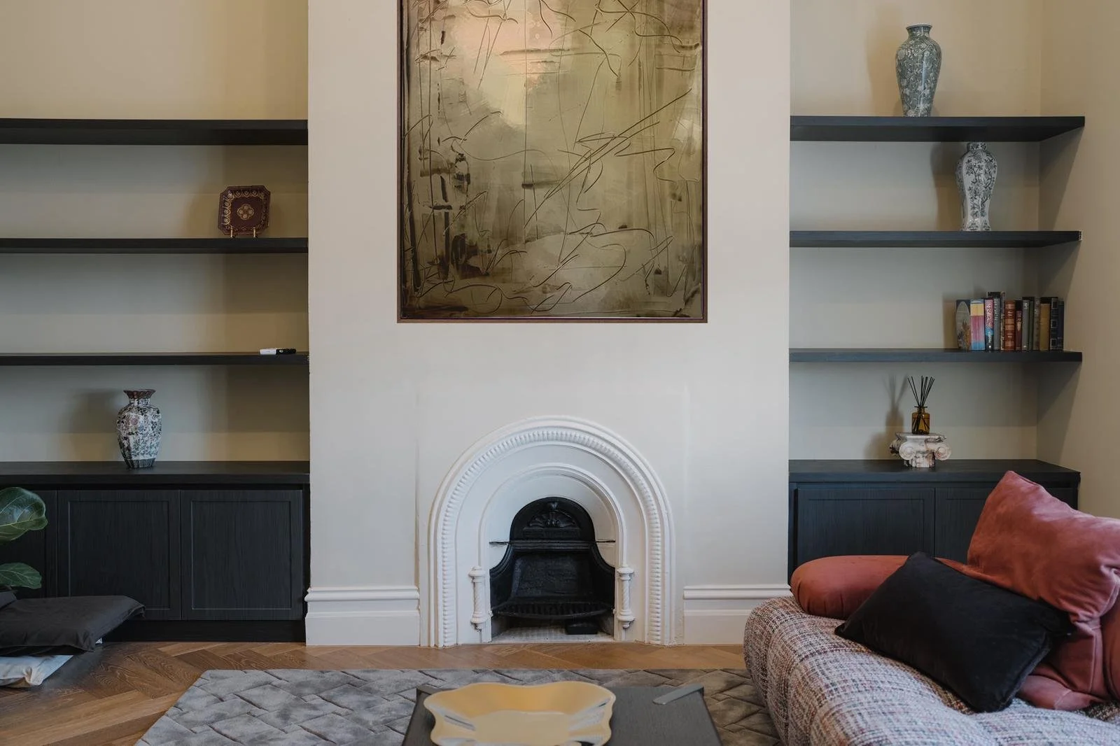 Styled Airbnb living room with arched fireplace and artwork in Fitzroy