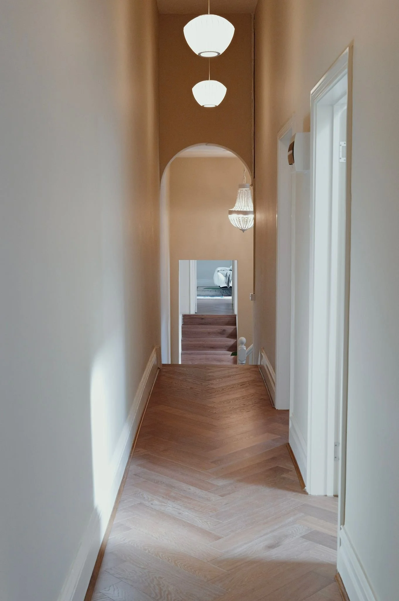 Hallway with herringbone timber floors and arched doorway, Brunswick Street Fitzroy