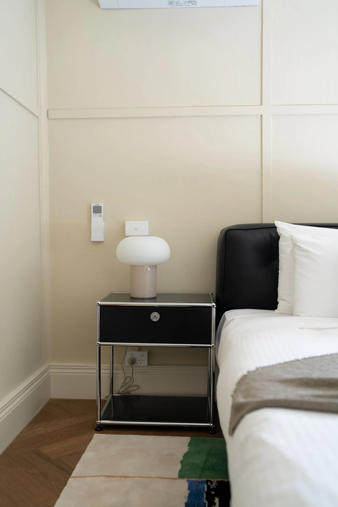 Styled Airbnb bedroom with black bedside table and mushroom lamp in Fitzroy