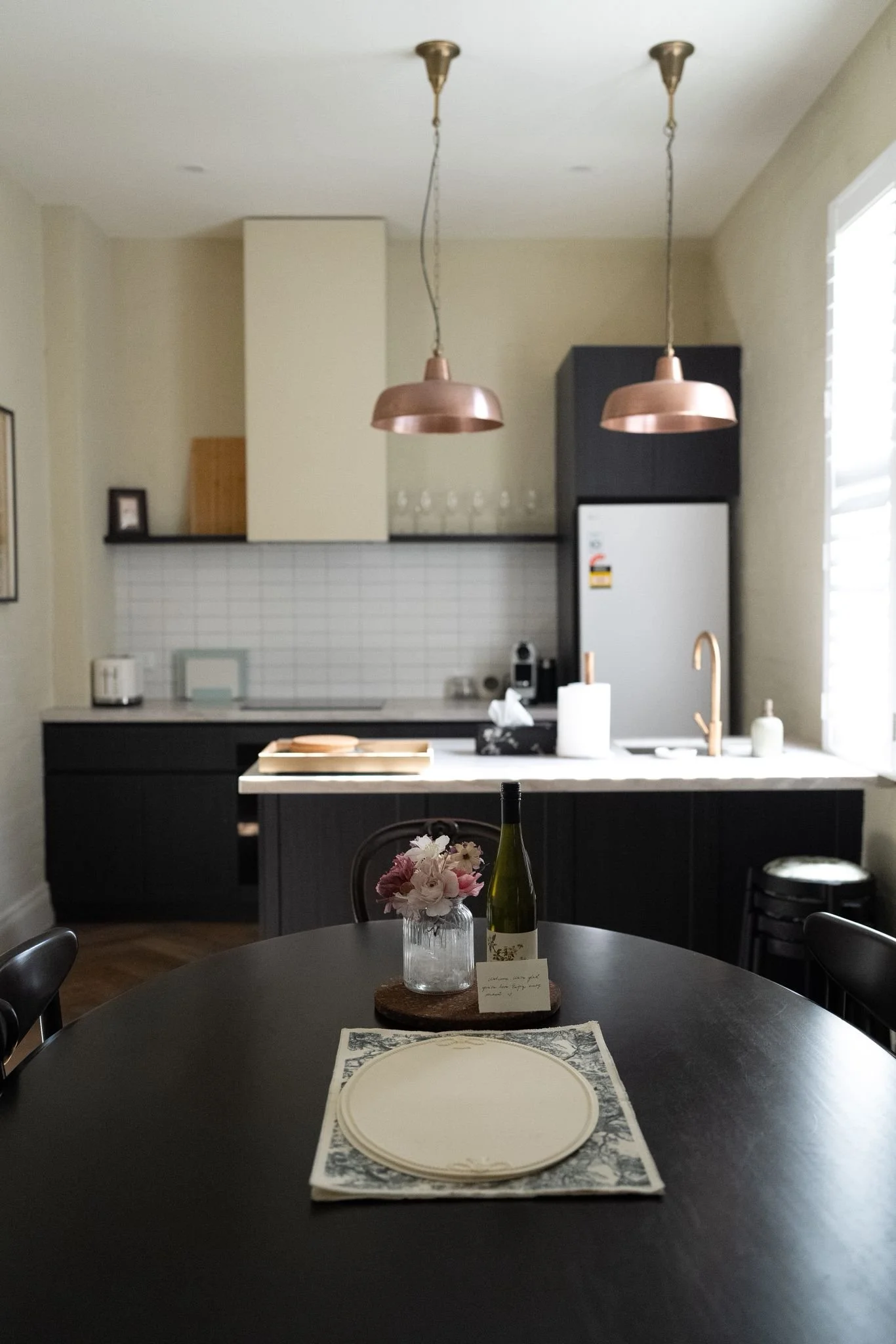 Airbnb kitchen with copper pendant lights and dining table in Fitzroy