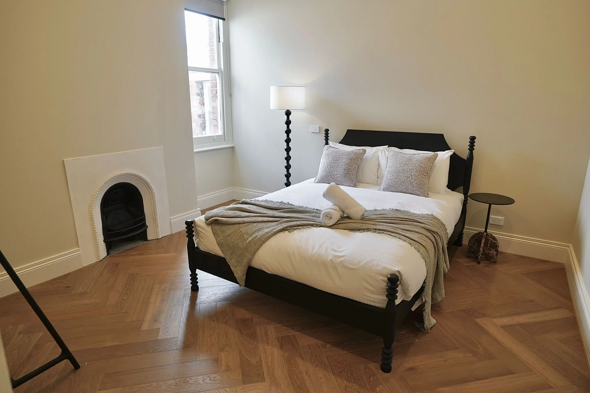 Airbnb bedroom with black spindle bed in Fitzroy short-stay apartment