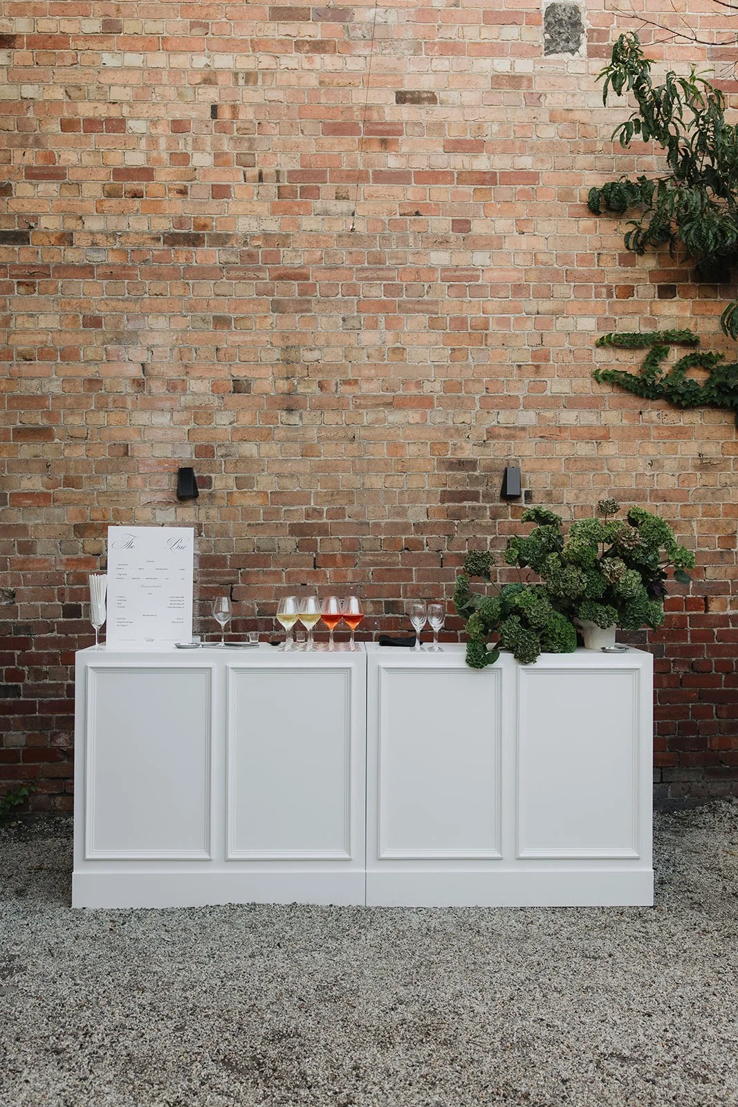 Rear courtyard with exposed brick wall and gravel for events at Collingwood Airbnb