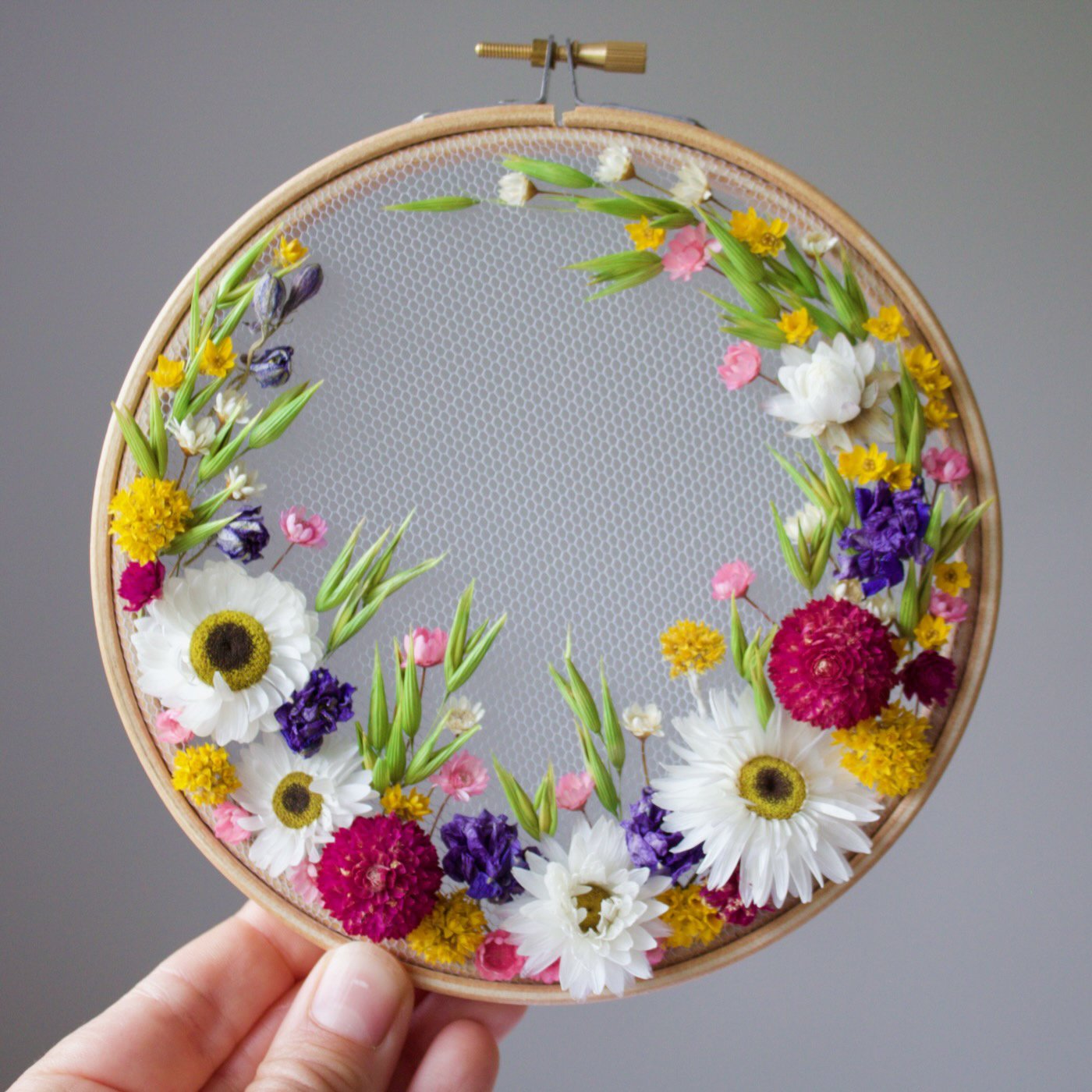 olga prinku embroidery on tulle kit number 2 held by Olga's hand collaboration with dried and floral
