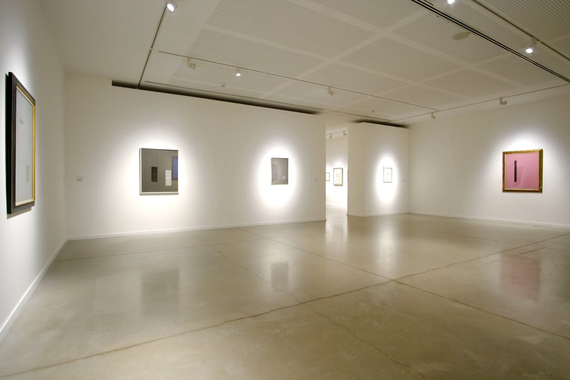 Vista general de la Sala 4 de MACA con obras de Arturo Vermi iluminadas sobre paredes blancas.