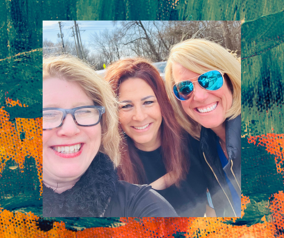 Three women smiling outdoors, with trees, power lines, and a blue sky in the background.