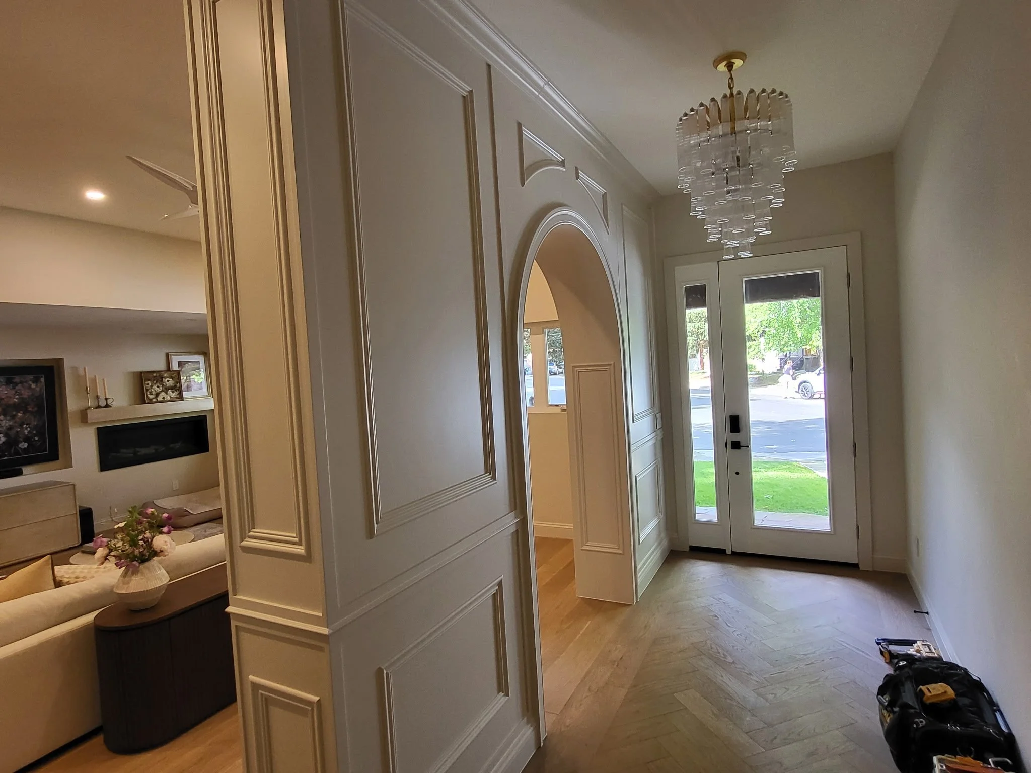 Traditional wainscoting details show off the archway in this entryway room separator and custom library bookcase in Durango, CO. 