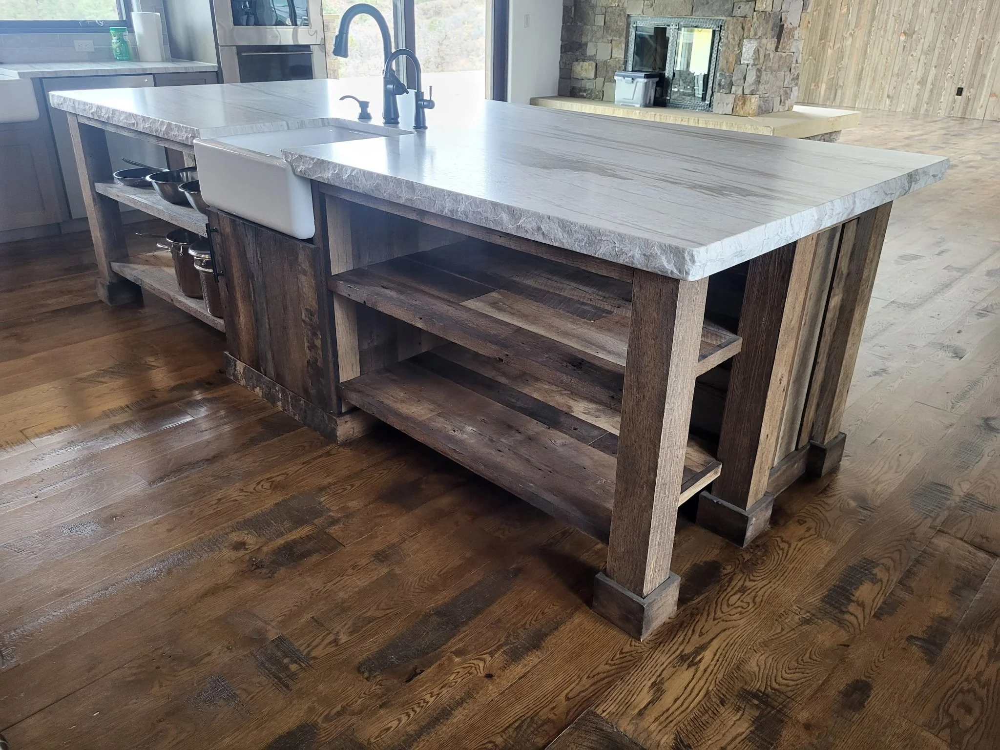 Custom kitchen island featuring open shelving and end panels made from real reclaimed wood—rustic style meets modern functionality for Colorado mountain home cabinetry.