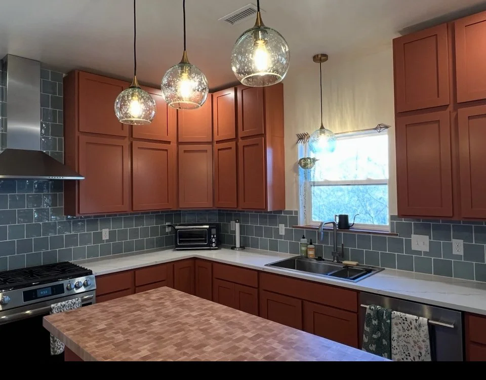 Custom kitchen island and new storage cabinets above wall units, cabinet refacing project with homeowner installation and modern countertop upgrade.