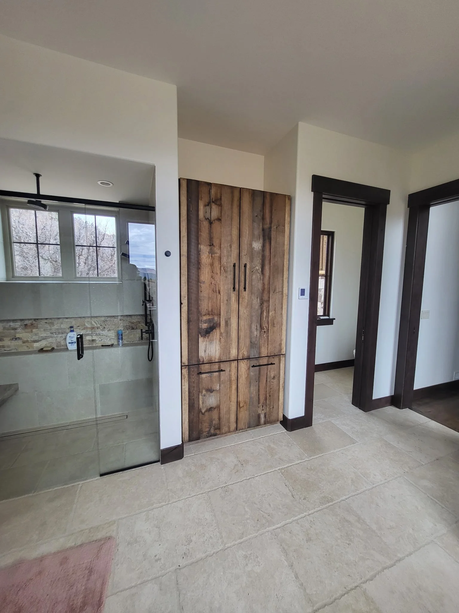 Rustic linen cabinet crafted from reclaimed wood, featuring concealed hampers and extra-large laundry storage inside.