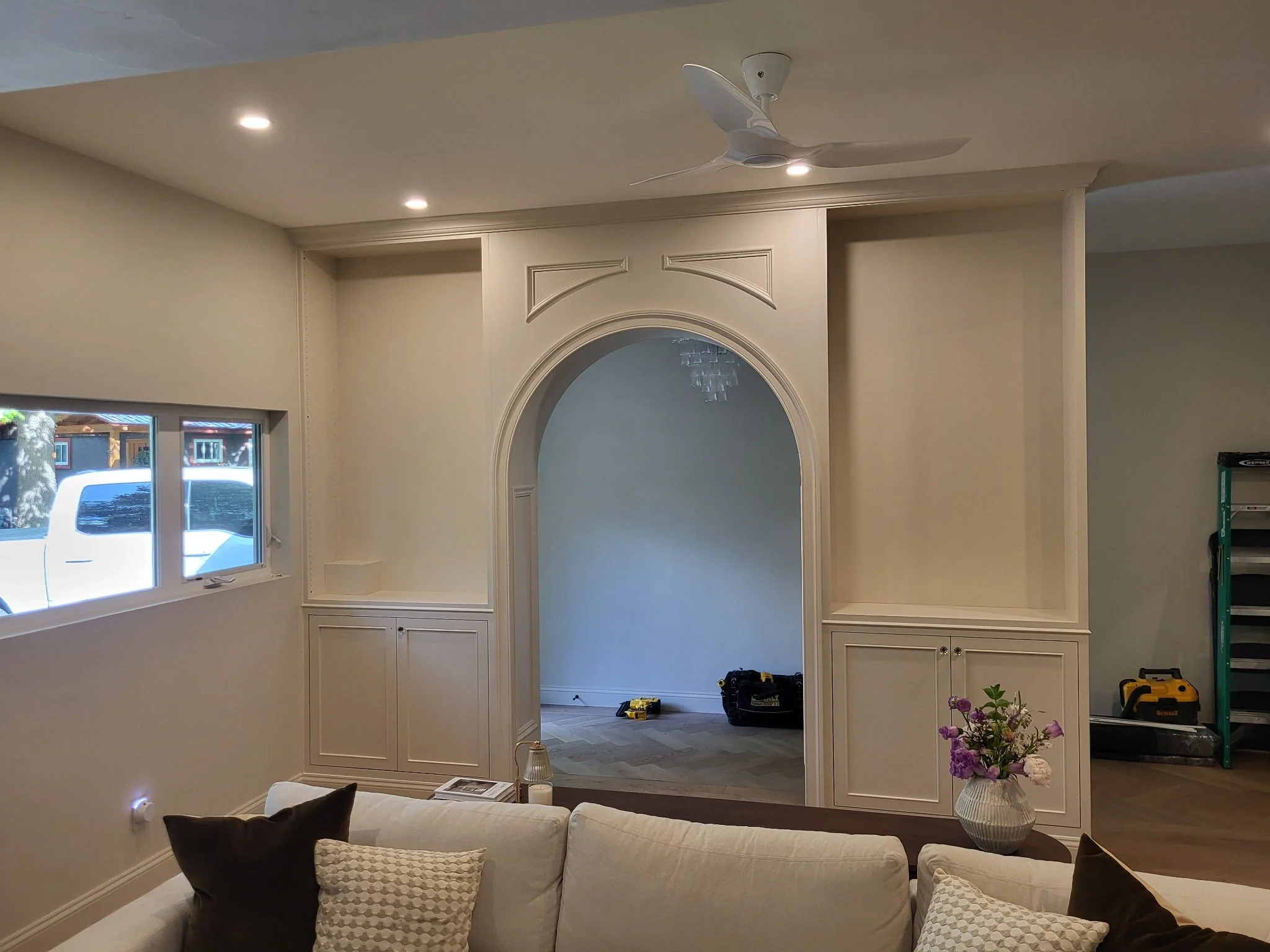 Traditional wainscoting detail on an entryway arched bookcase room separator.