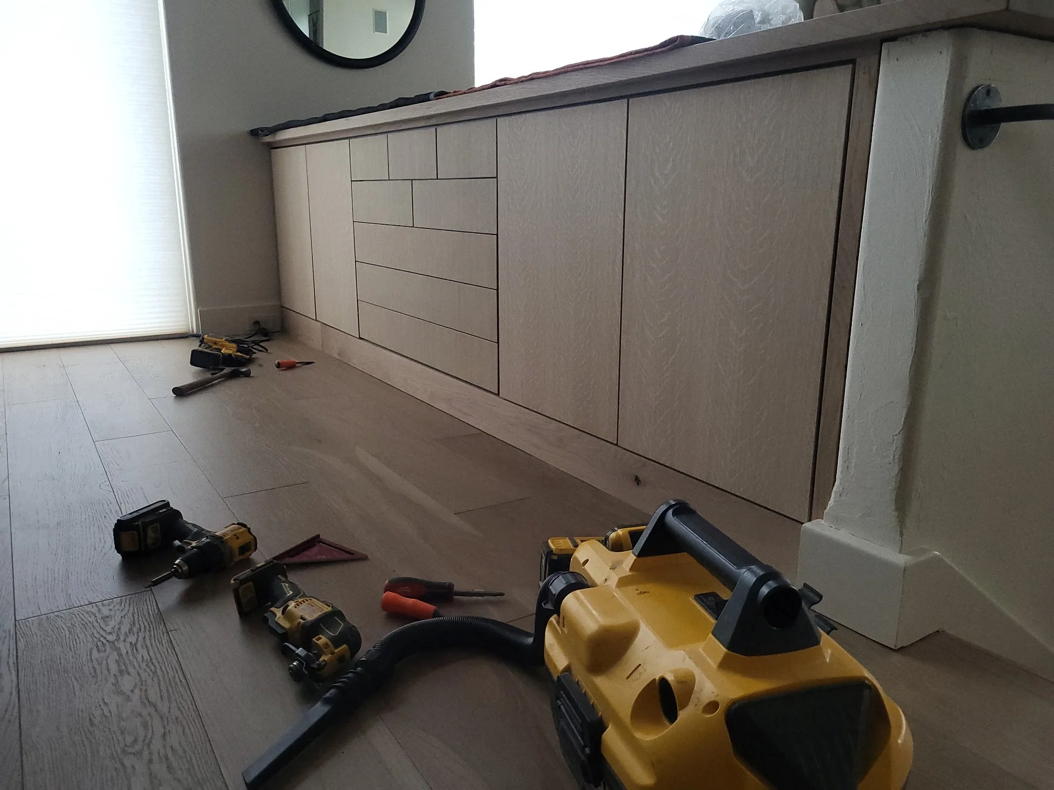 Close-up of updated living room cabinets featuring continuous grain white oak doors, push-to-open hardware, and solid white oak countertops—custom cabinet refacing for a fresh, modern look by ACW.