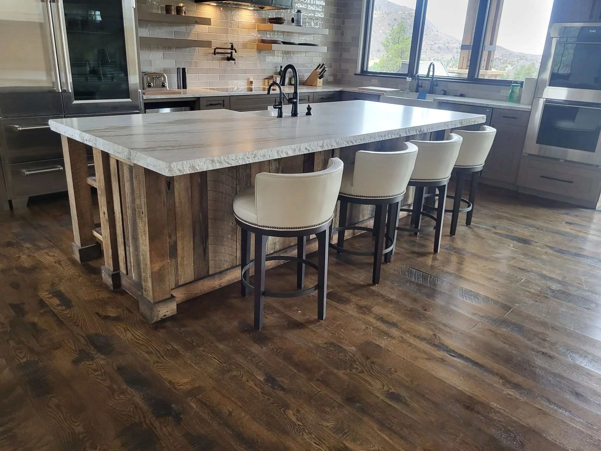 Large rustic kitchen island with faux box beam posts skinned and trimmed in reclaimed wood—durable construction and timeless design by Animas Craft Woodworks.