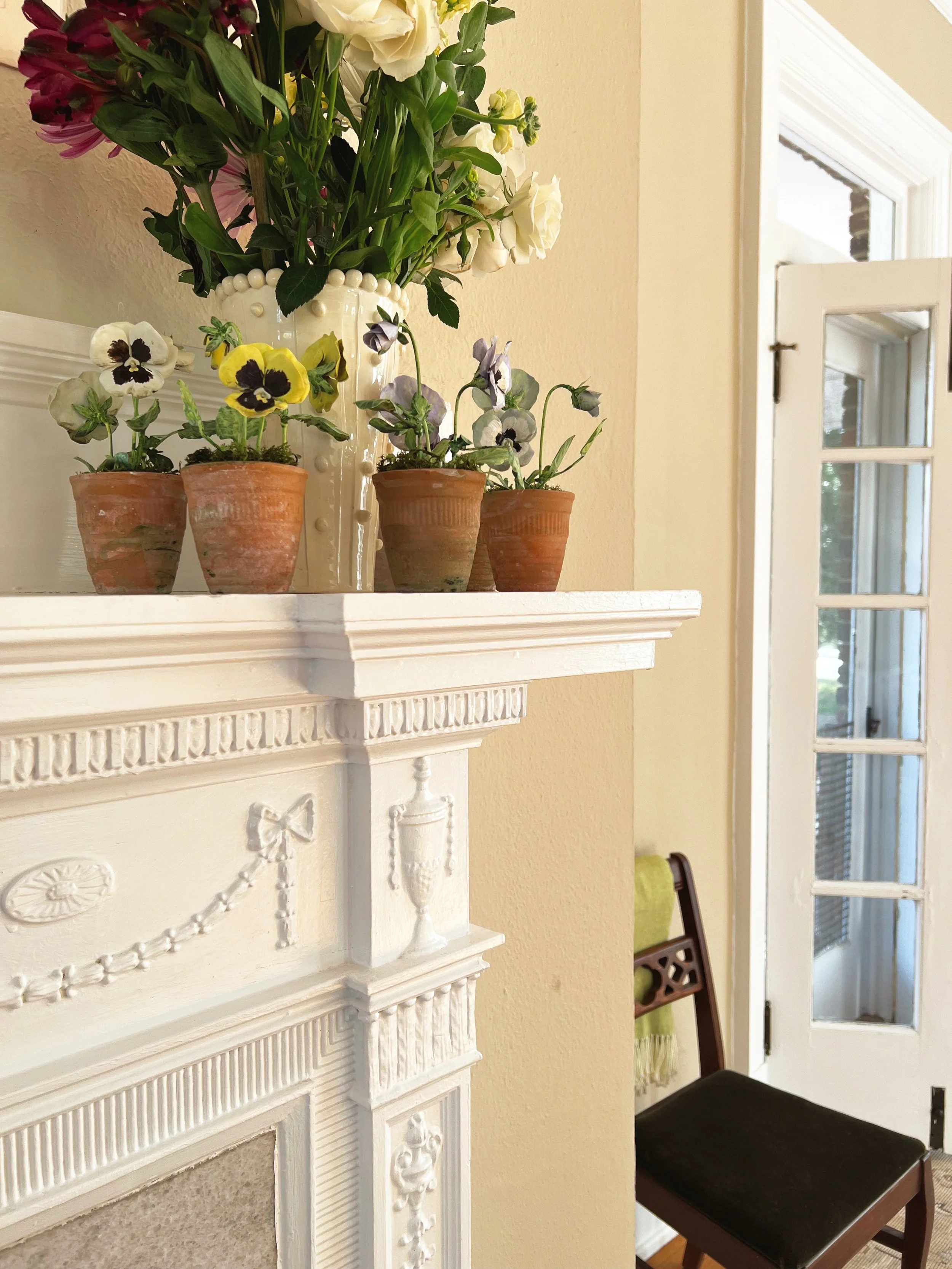 vintage-pansies-potted-tole-on-mantel-blanket-on-chair.JPG