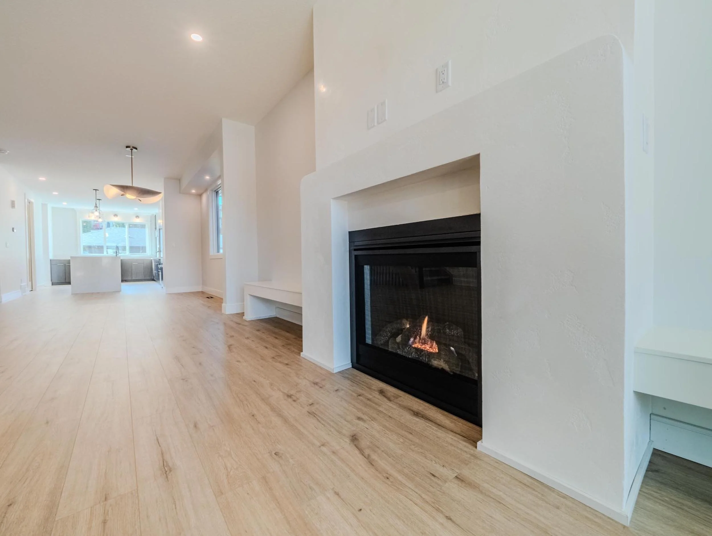 Minimalist plaster fireplace in a modern living room by Omni Homes Master Builder.