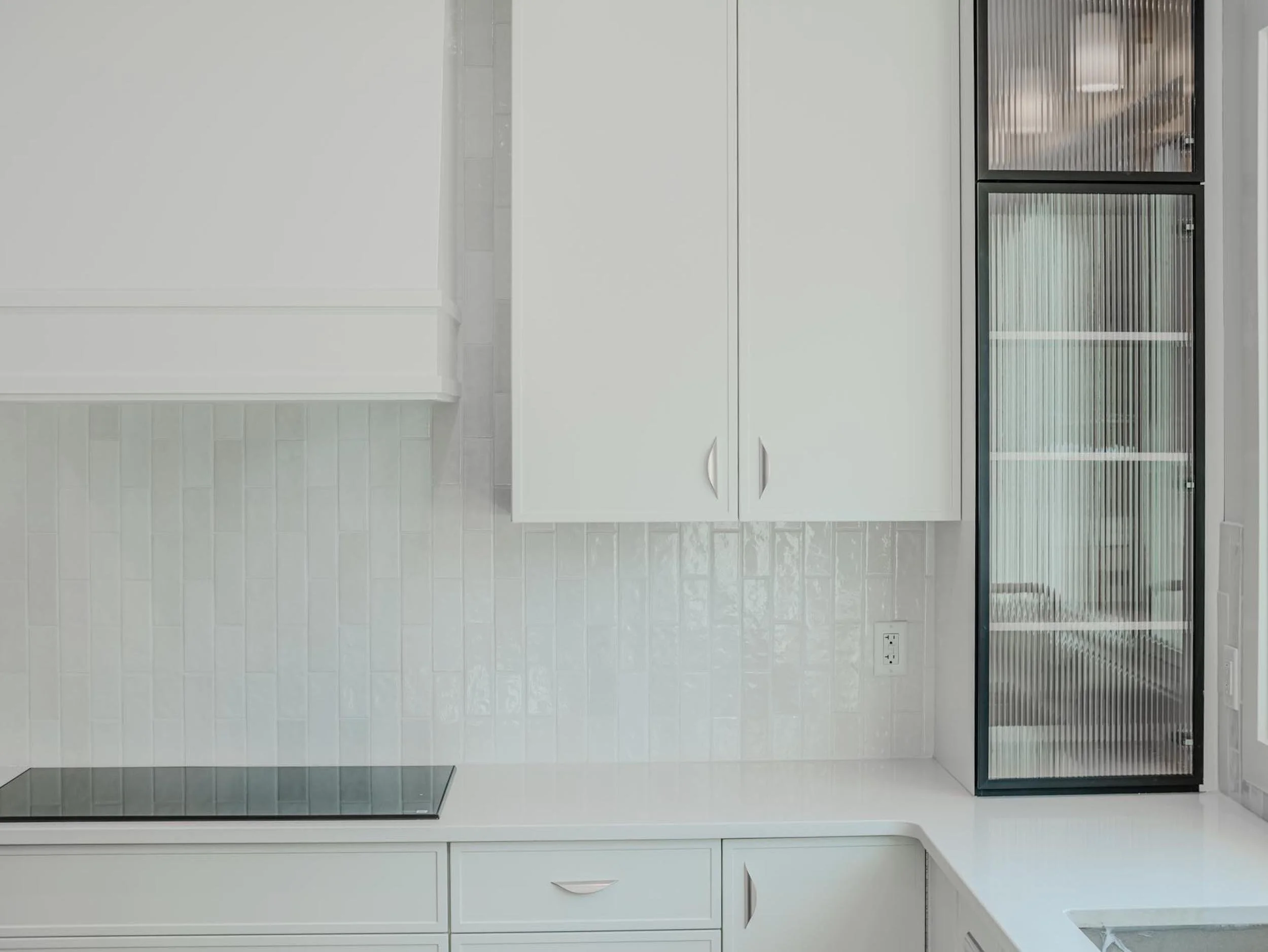 High-end kitchen cooktop and textured tile backsplash in a custom-built Edmonton infill.