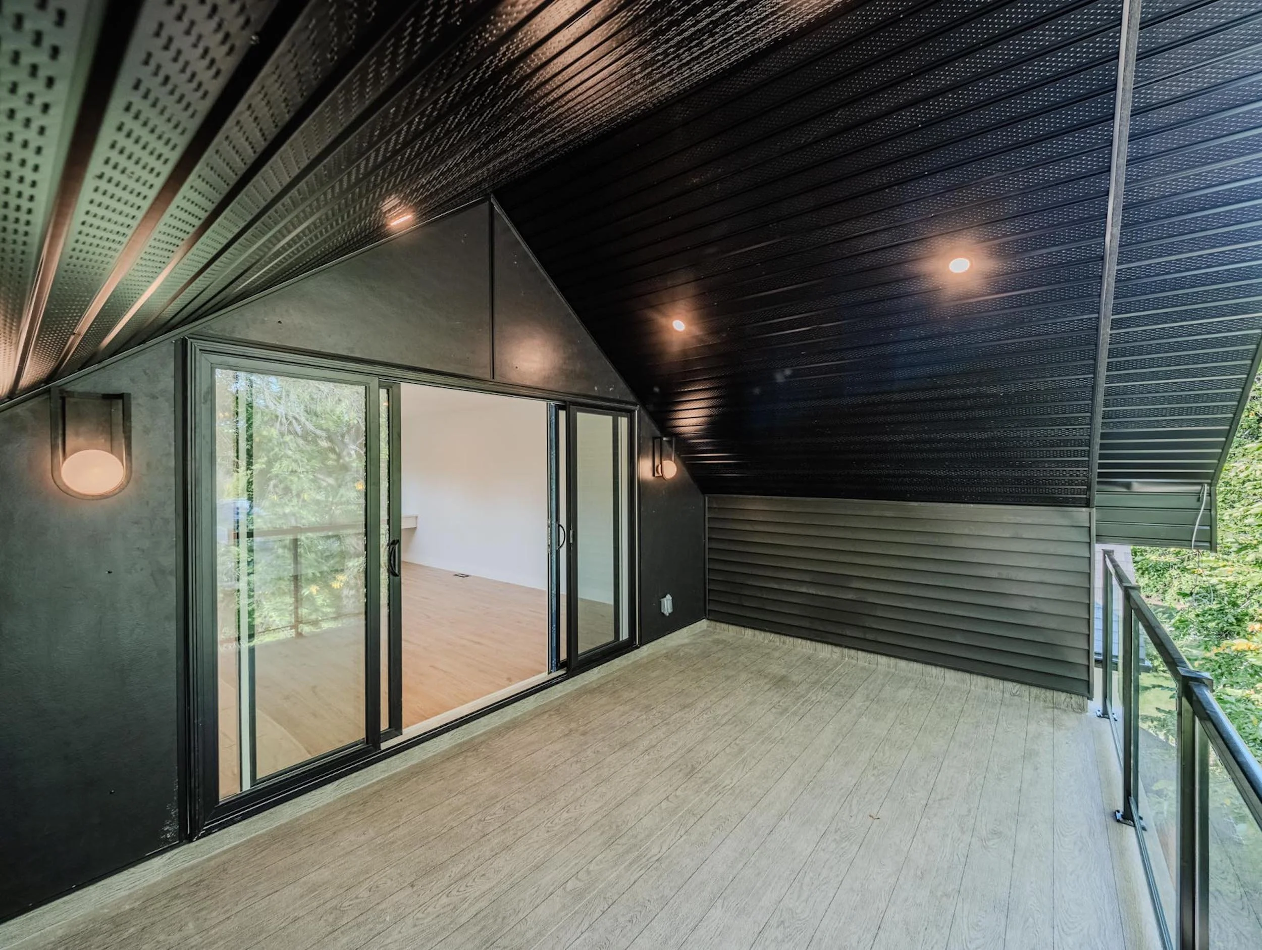 Architectural third-story sky loft featuring vaulted ceilings and a glass-walled balcony retreat