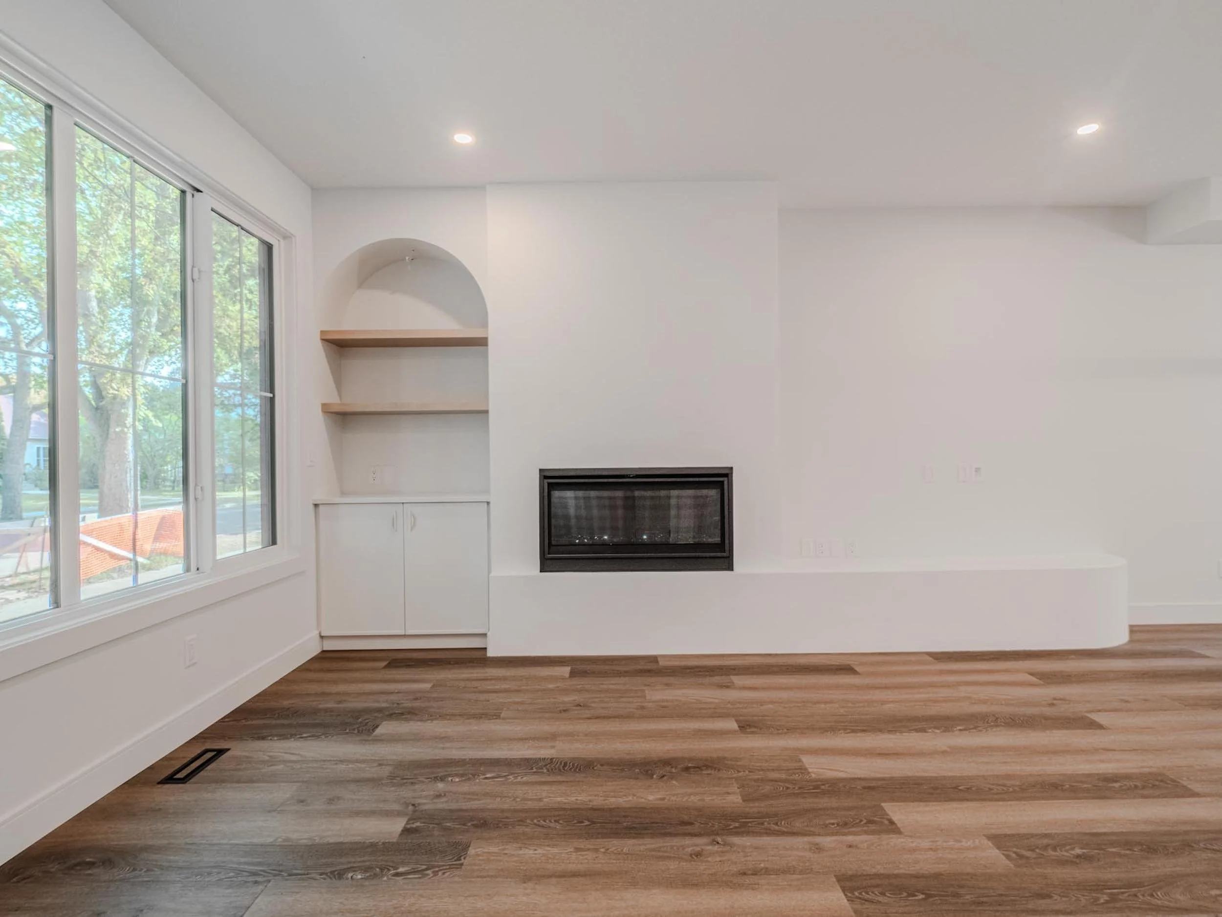 Linear gas fireplace with a custom curved ledge and arched niche, highlighting the unique silhouette of The Belgravia Curve.