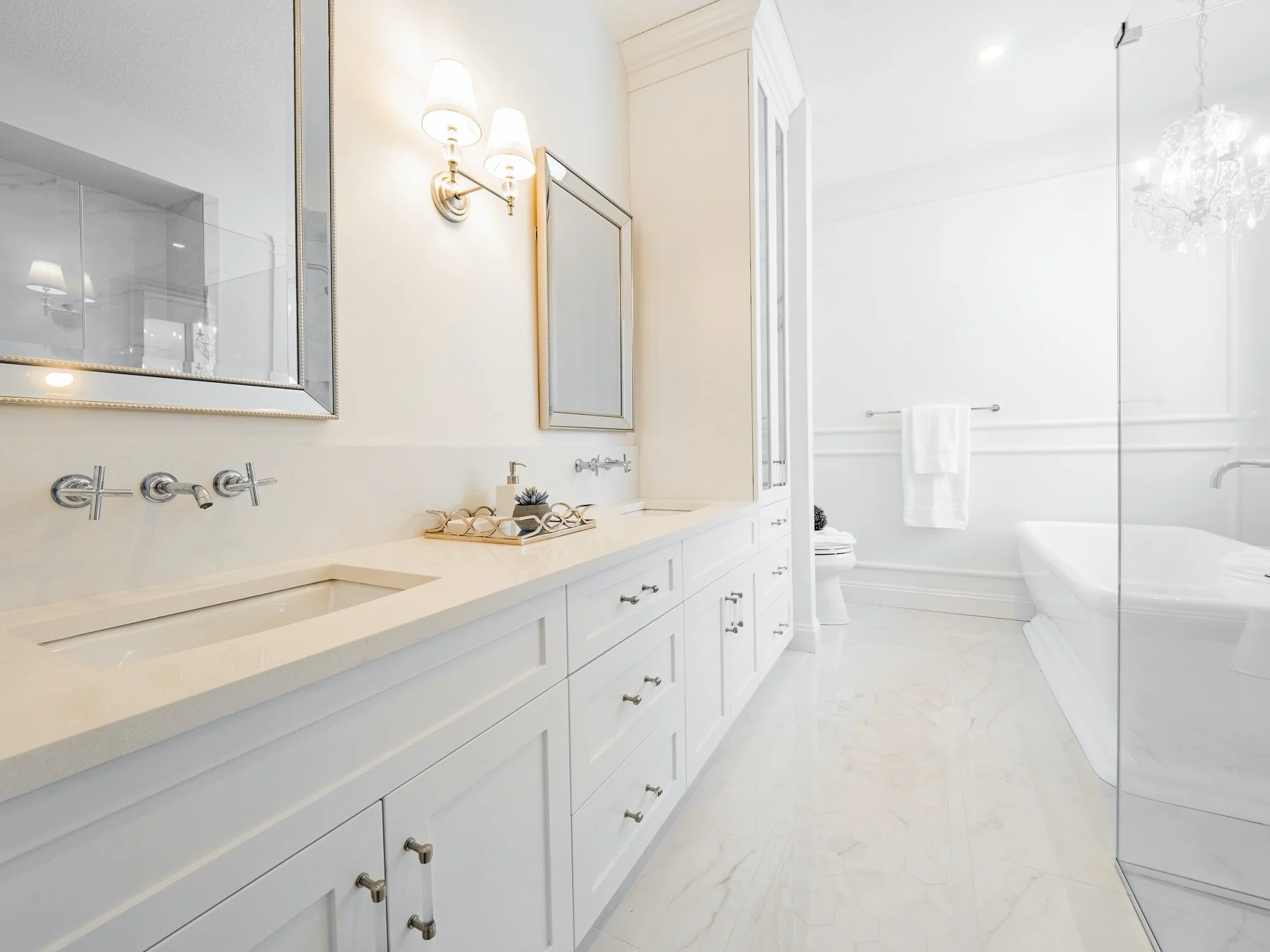 Luxury vanity with Restoration Hardware Wilshire sconces, HomeSense mirrors, and Kohler Purist wall-mounted faucets.