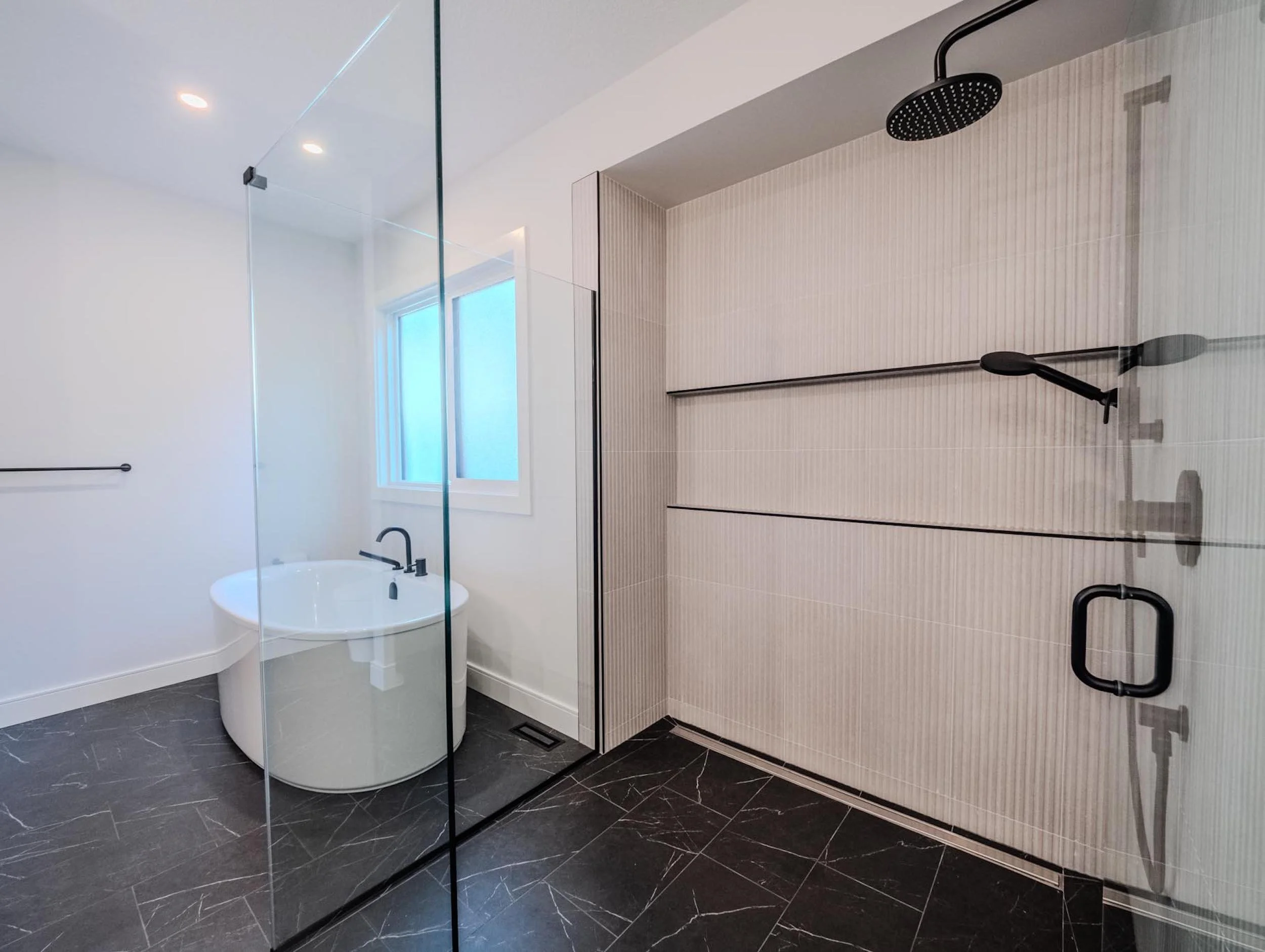Luxury curbless walk-in shower and a deep soaking tub in a high-performance home.