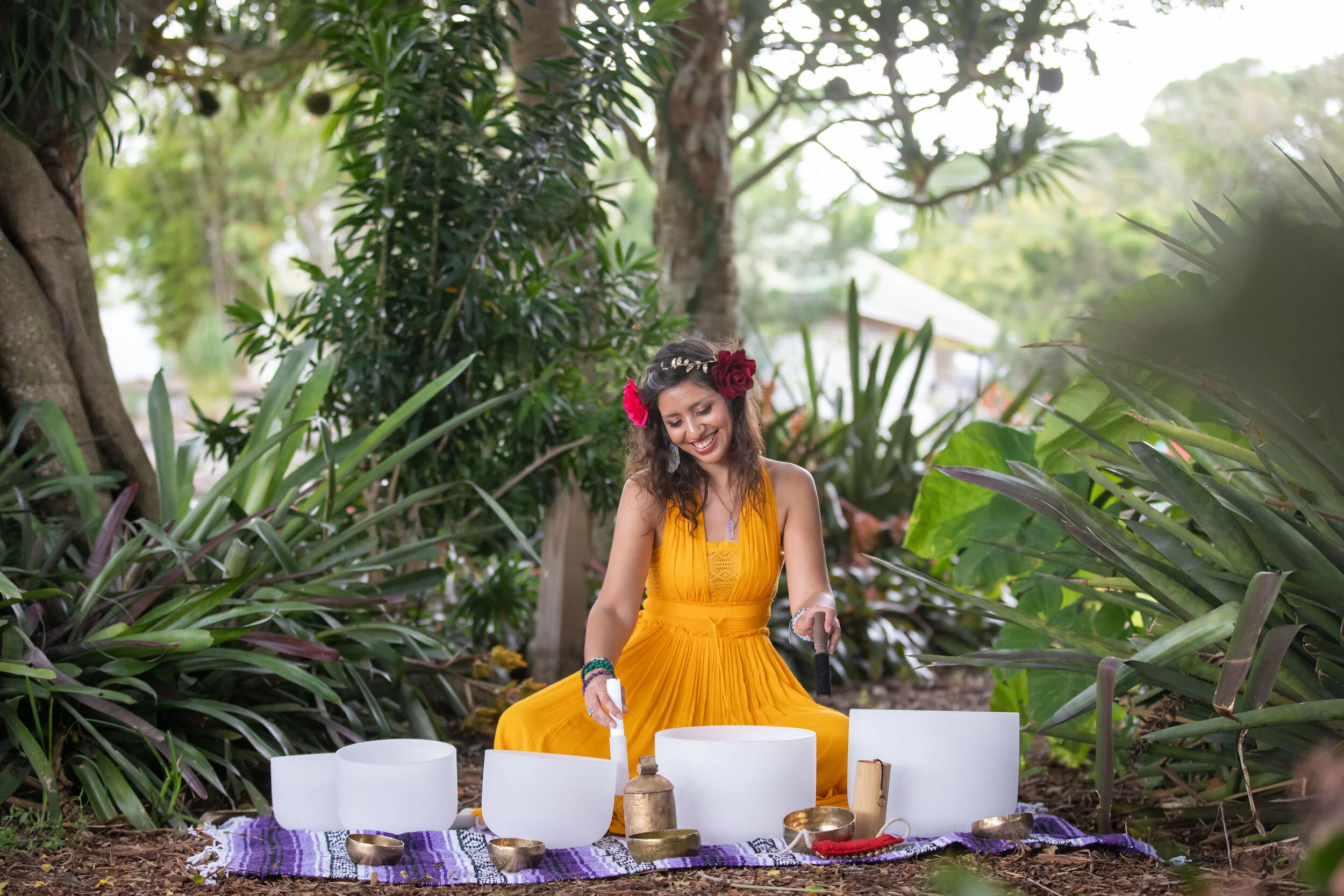 Zen Seraphine seated among crystal singing bowls in a garden