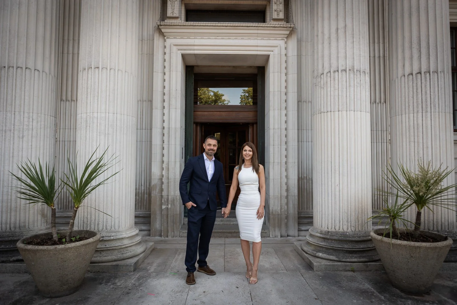 bride and groom at City Hall hand in hand