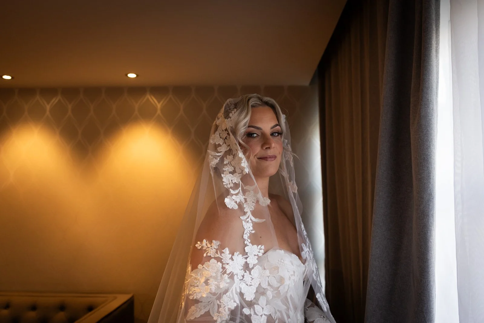 bride poses for photograph stood in veil